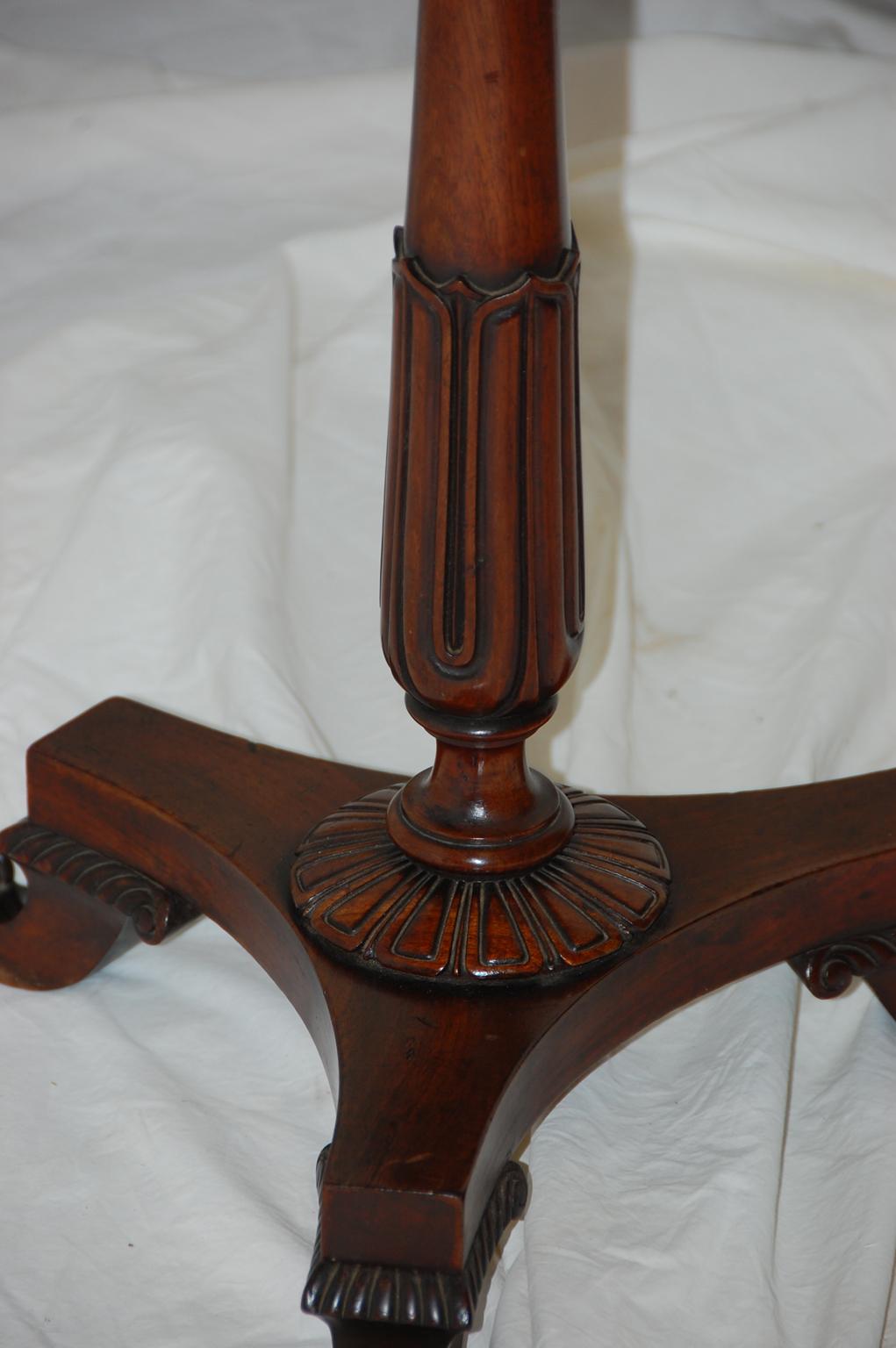 English Regency period pedestal side table in mahogany with delicate carved stem, inset white marble top with broad mahogany banding. The acanthus leaf carving to the stem and the carved upswept feet set this table apart from the normal. It can be