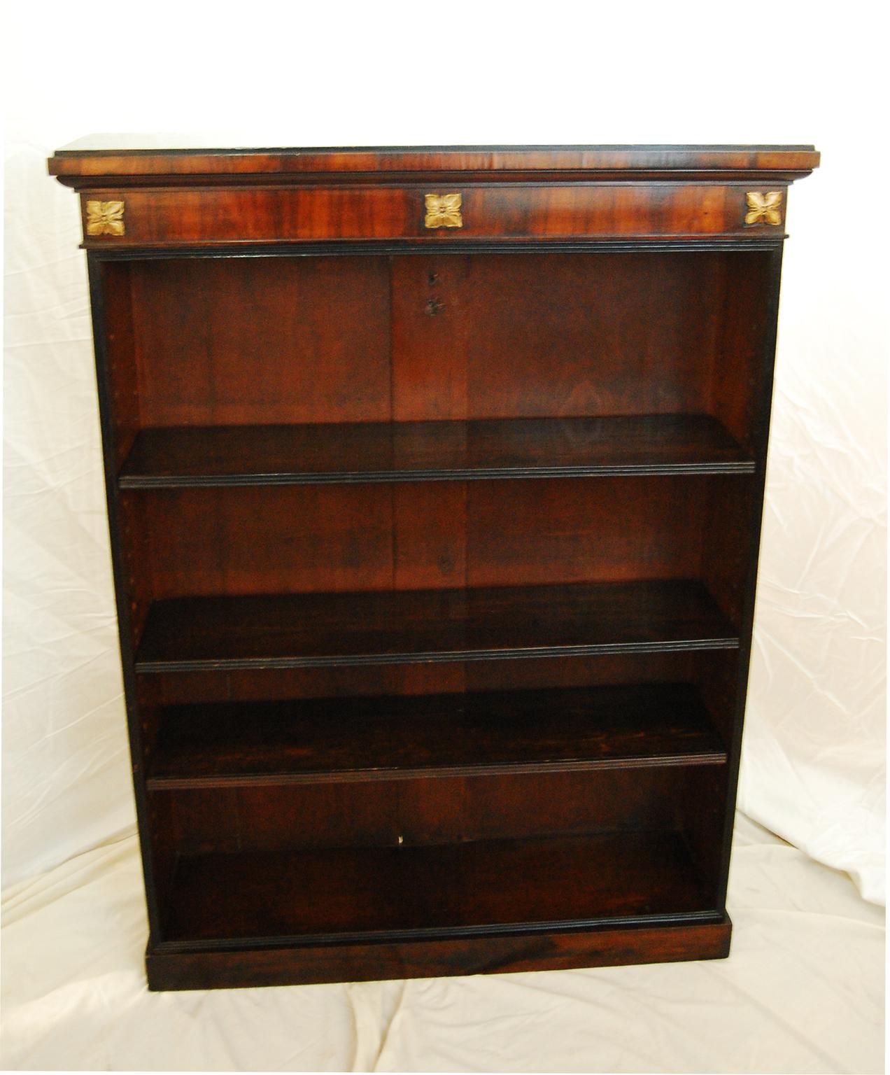 
 English Regency rosewood bookcase with three adjustable shelves. This bookcase is set apart by having an ebonized top and ebonized reeded moldings to the shelves and the carcass. The classic Regency detailing of reeded moldings is subtly accented