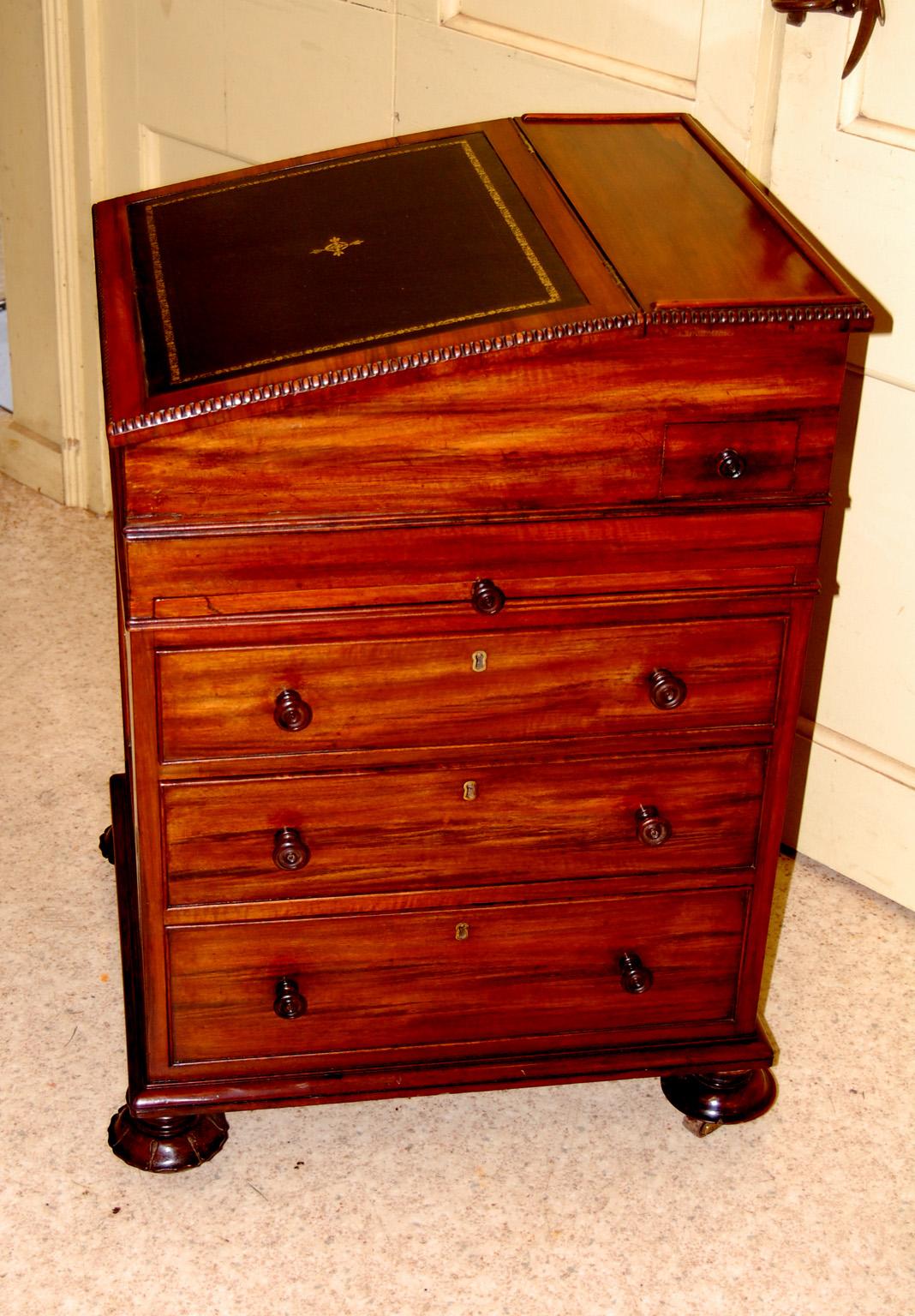  English Regency rosewood davenport with three side graduated drawers, a hinged slide out pen and ink drawer that will rotate for ease of use, molded lift top with hand tooled and dyed leather (replaced leather), two interior drawers,  and two 13