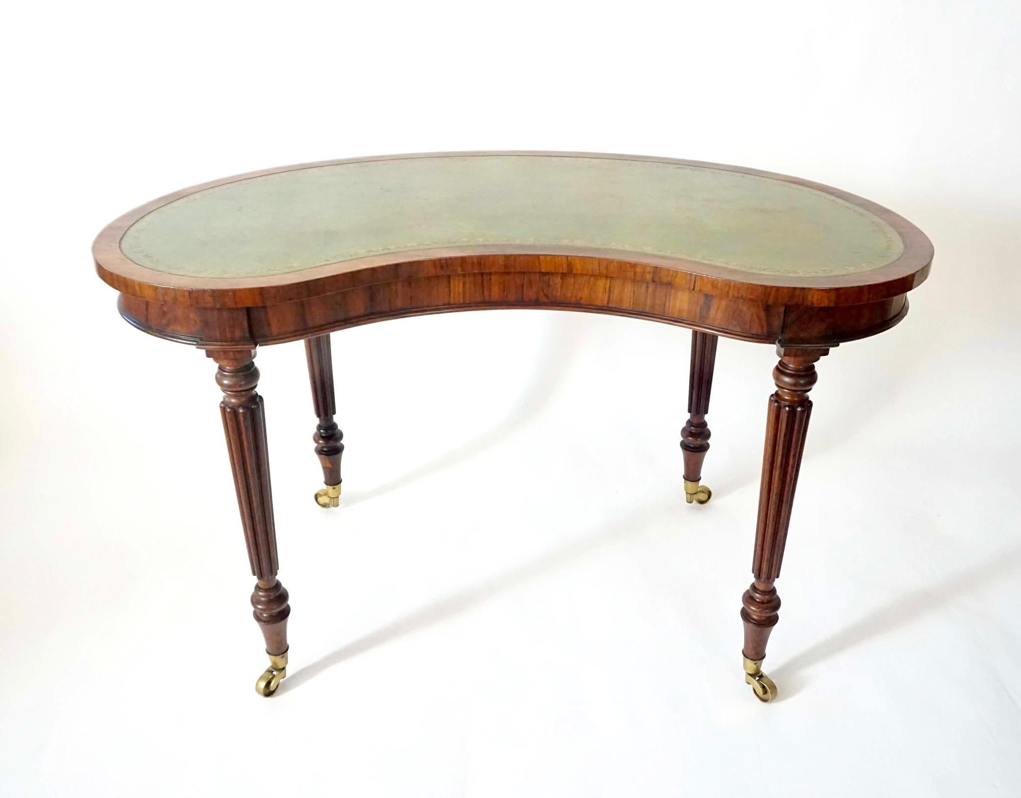 An elegant and rare circa 1815 English regency period rosewood writing table of 'kidney' form by legendary English cabinetmaking firm Gillows of Lancaster and London, the shaped top having possibly original gilt-tooled green leather inset writing