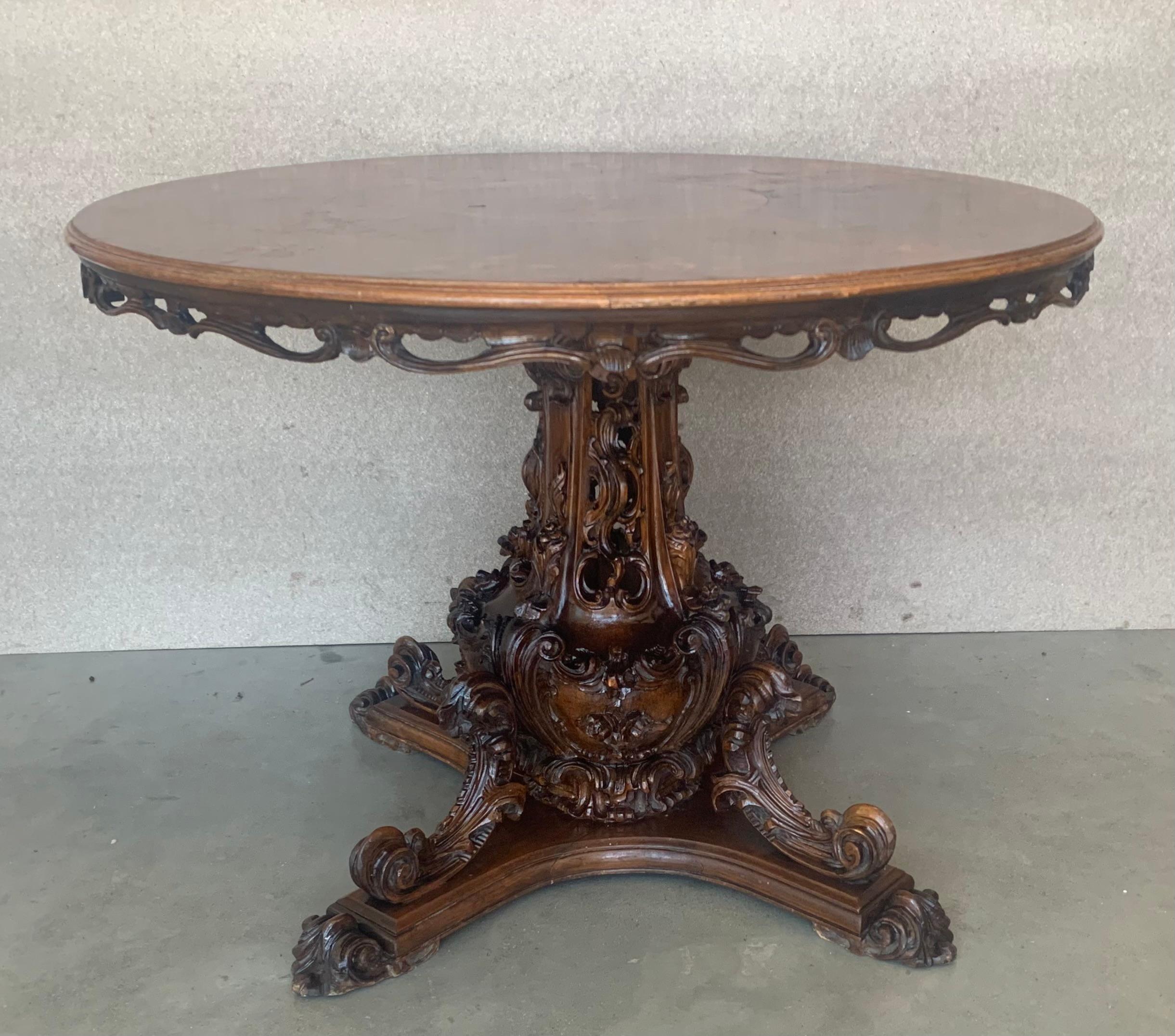 A very fine Rococo-influenced Regency table in mahogany with round marquetry top and turned and beveled column on quatre-form base ending in 