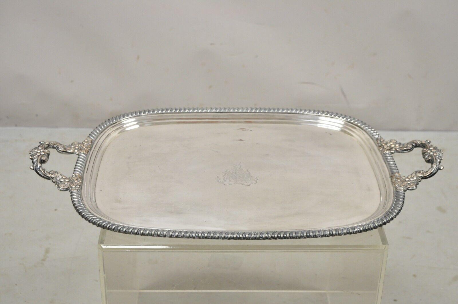 Antique English Regency silver plated twin handle platter tray with crest and shield. Item features ornate twin handles, engraved crest with shield and helmet, circa early to Mid-20th Century. Measurements: 1.75