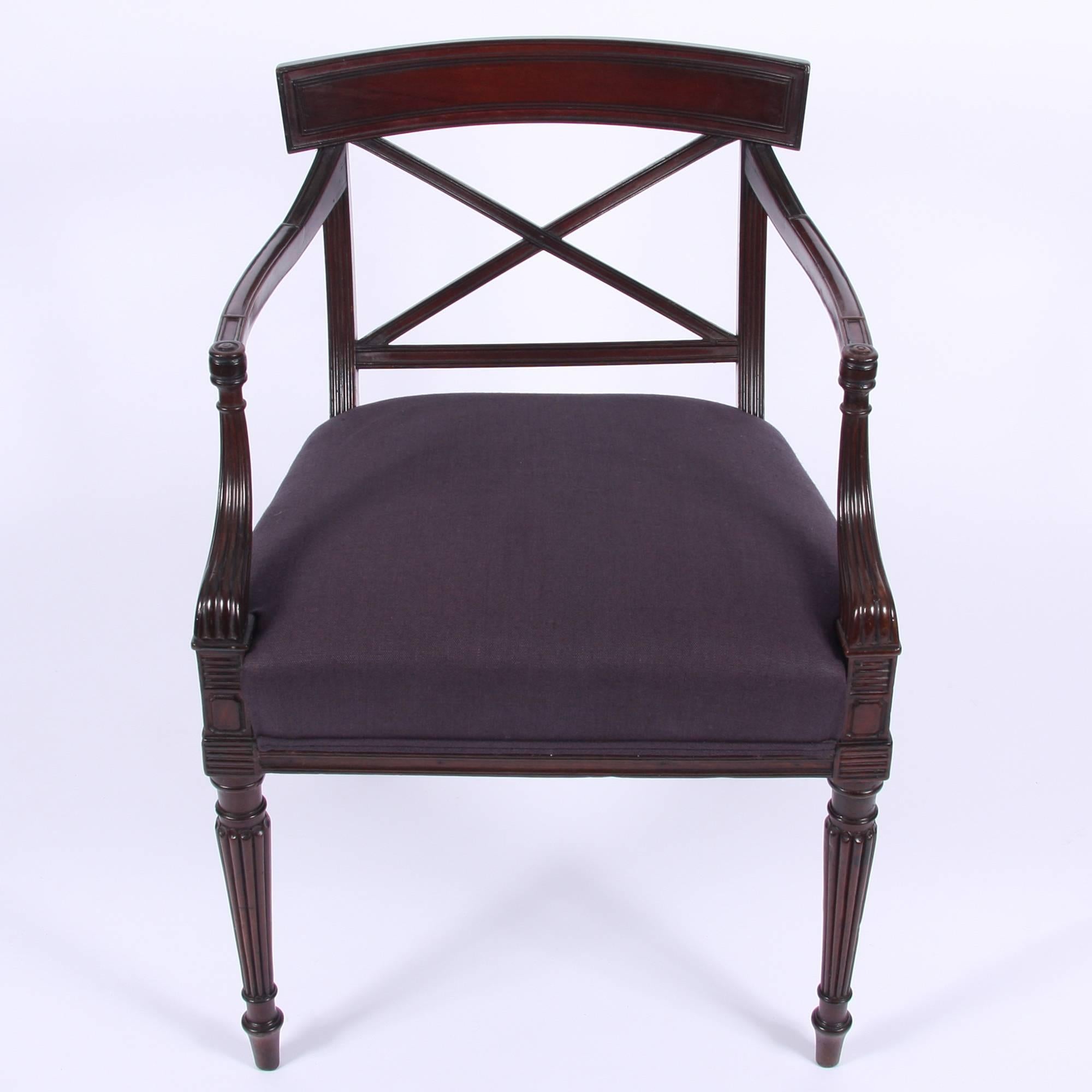 An early 19th century English single mahogany Regency armchair, with newly upholstered seat pad. Cross back with reeded armrests and front legs.