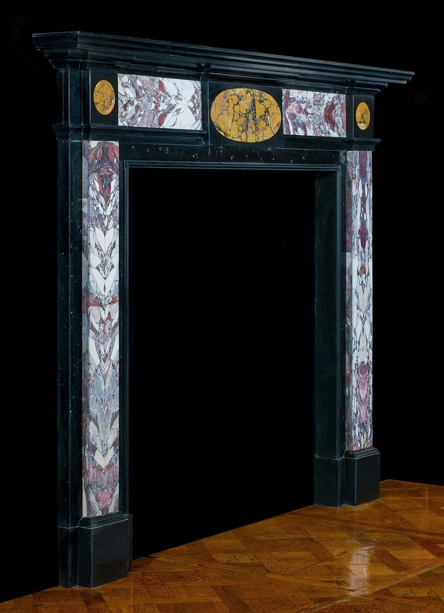 A very smart English Regency specimen marble chimneypiece in Kilkenny black fossil marble inlaid with Breche Violette marble panels which have been cut and opened like a book to reveal symetrical veining. The oval plaque on the frieze and the