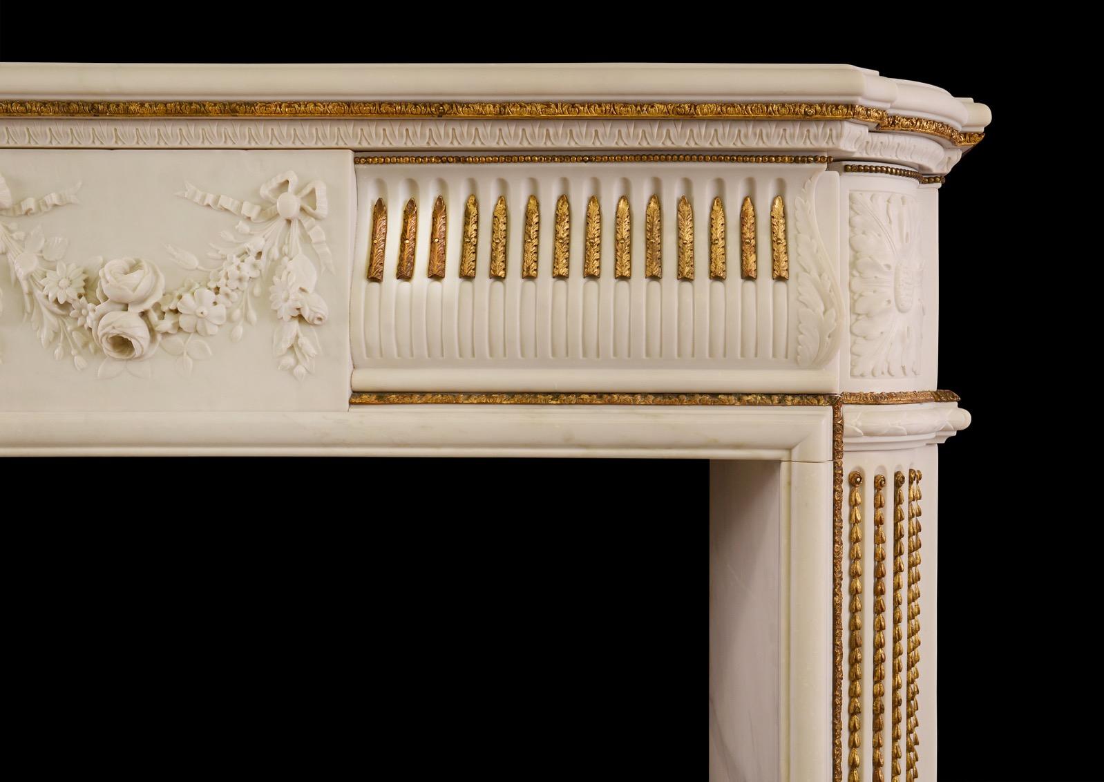 A good quality period Regency fireplace in statuary white marble, with adorned brass ormolu enrichments. The frieze with finely carved centre blocking of tied swags, ribbons and flowers, flanked by stop-fluted frieze with delicate ormolu husks