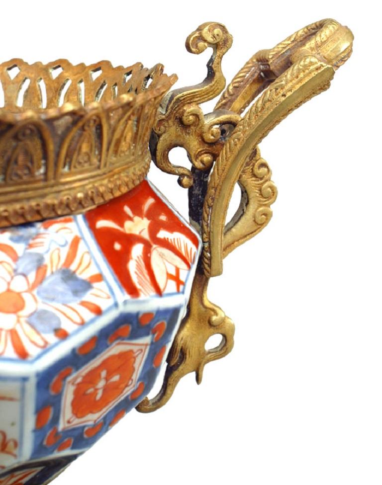 English Regency-style (19th Century) Imari porcelain centerpiece with bronze trimmed base and handles and round filigree top.
 