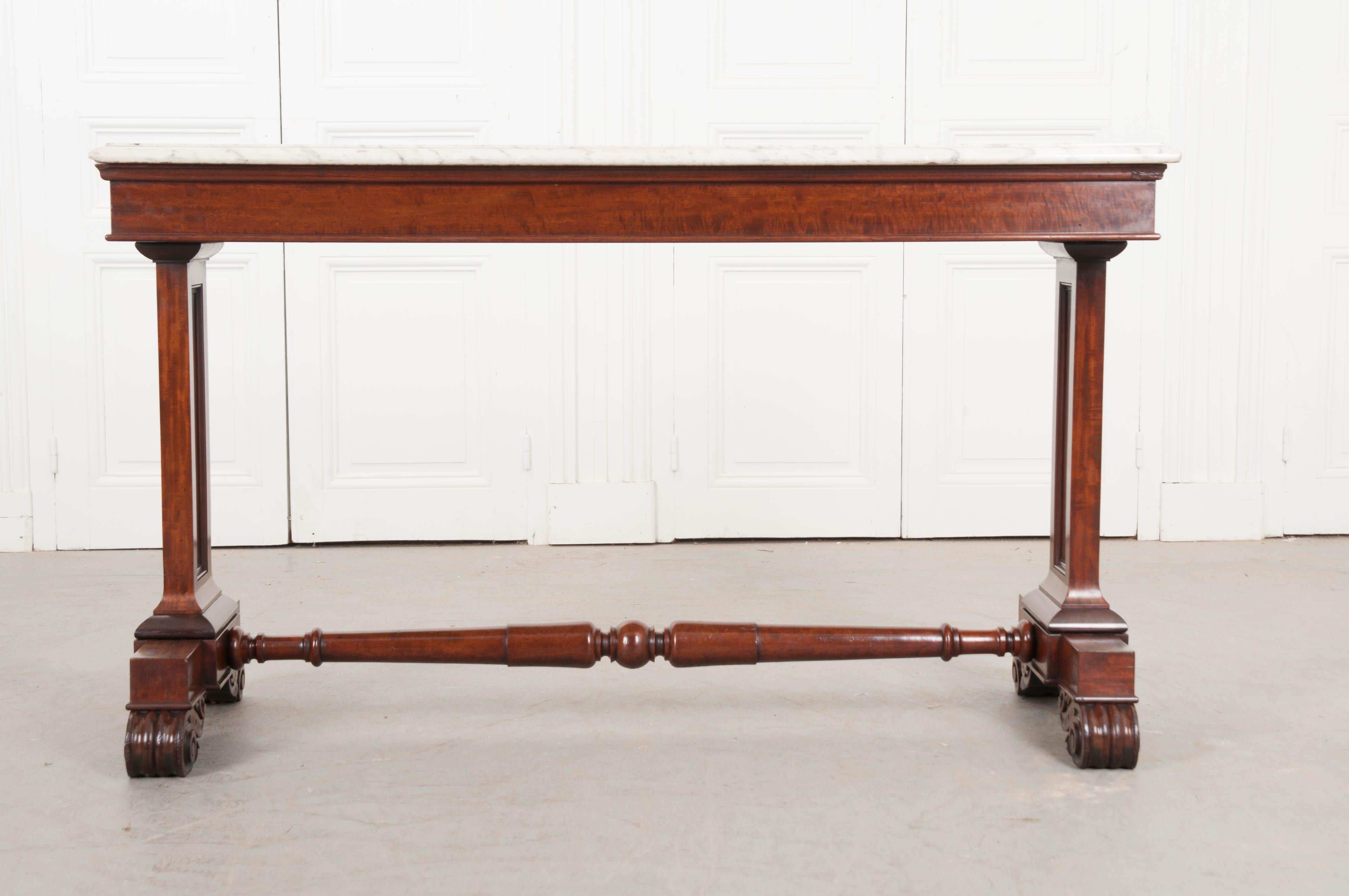 A handsome 19th century Regency style console hall table with marble top from England. The white marble top is in good antique condition with an inverted ogee edge, finished on three sides. The large marble top rests on an apron that is lifted by
