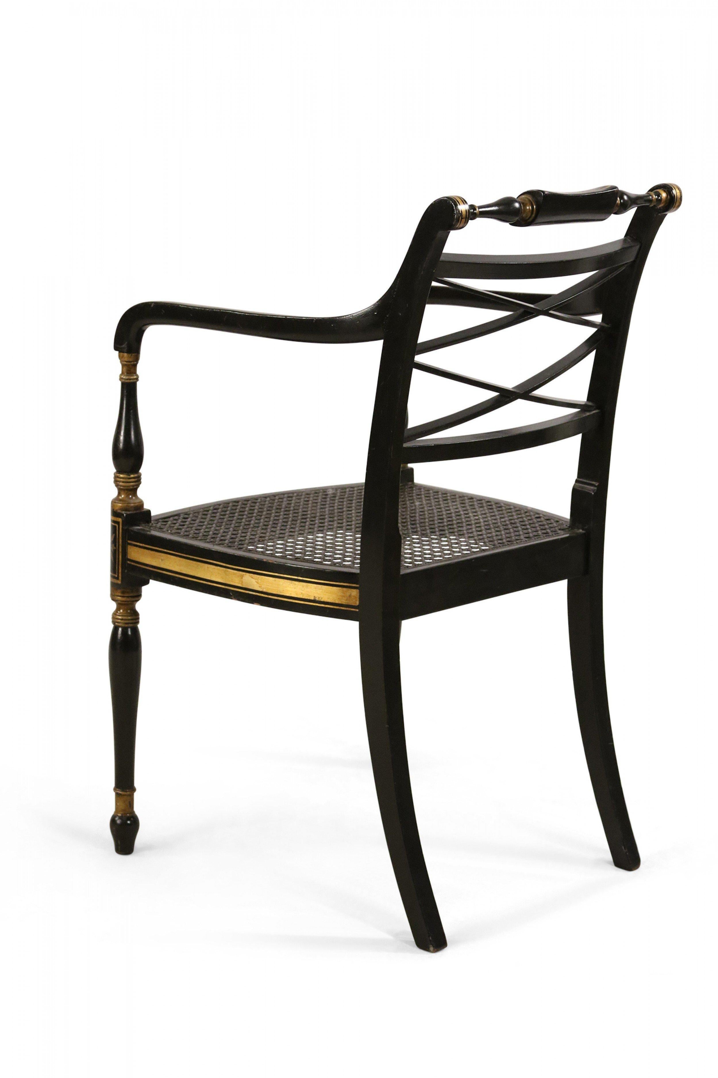 English Regency-style (20th Century) black and gold painted armchair with x-shaped backs, turned top rails and arms, and black painted cane seats.
  