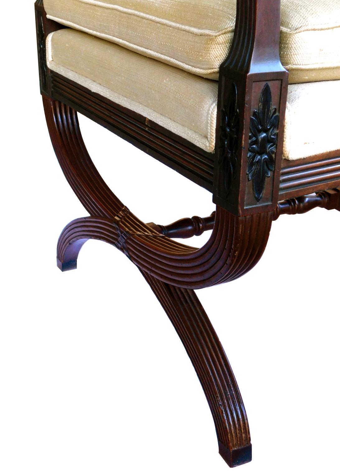 The open back with carved Greek Key rail above reeded downscrolled arms with foliate carving; all raised on Curule form legs joined by turned stretchers.