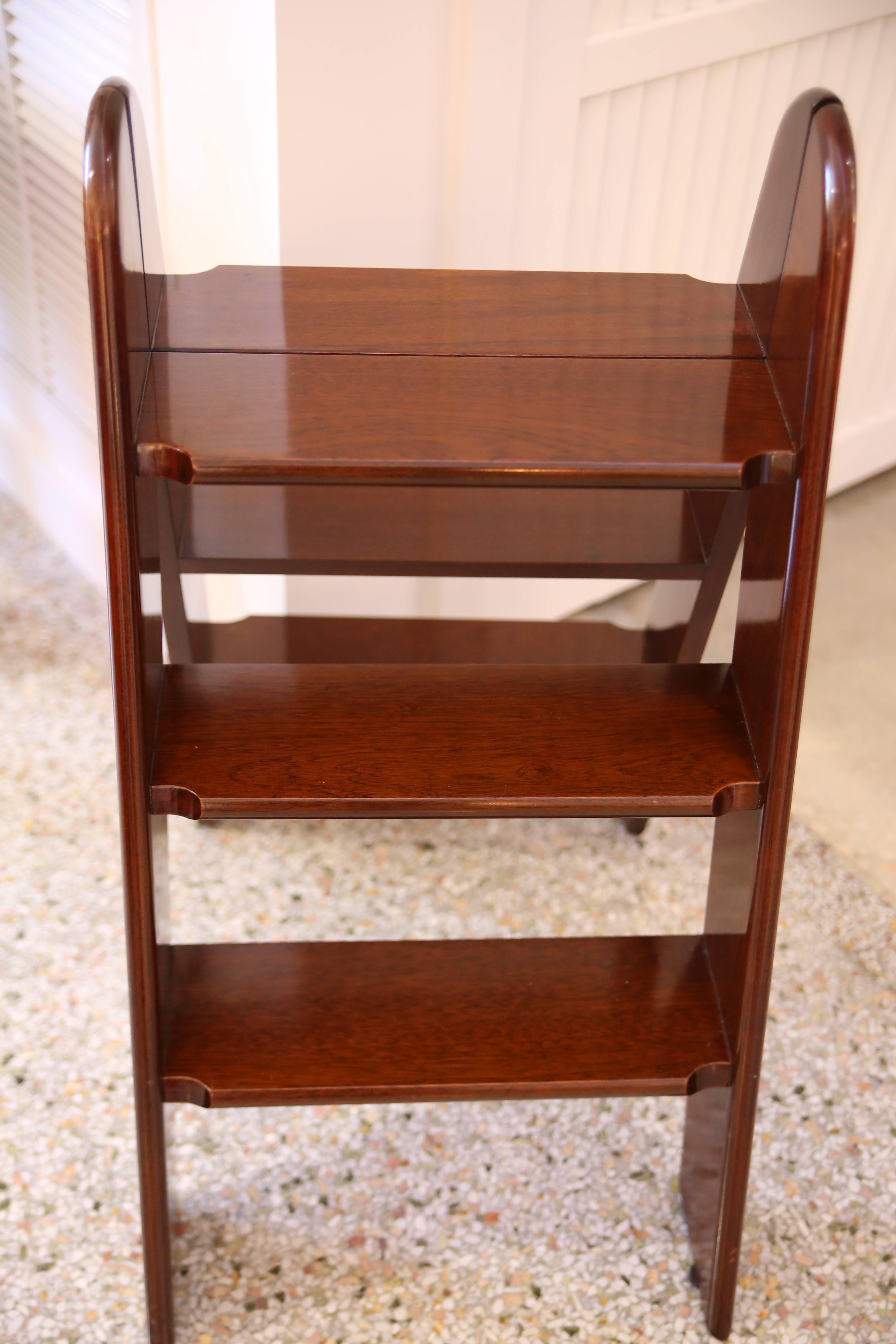 This stylish piece will make for the perfect side table or as an accent piece in your library. With its polished dark mahogany wood frame accented with brass the piece is clean-lined and handsome.