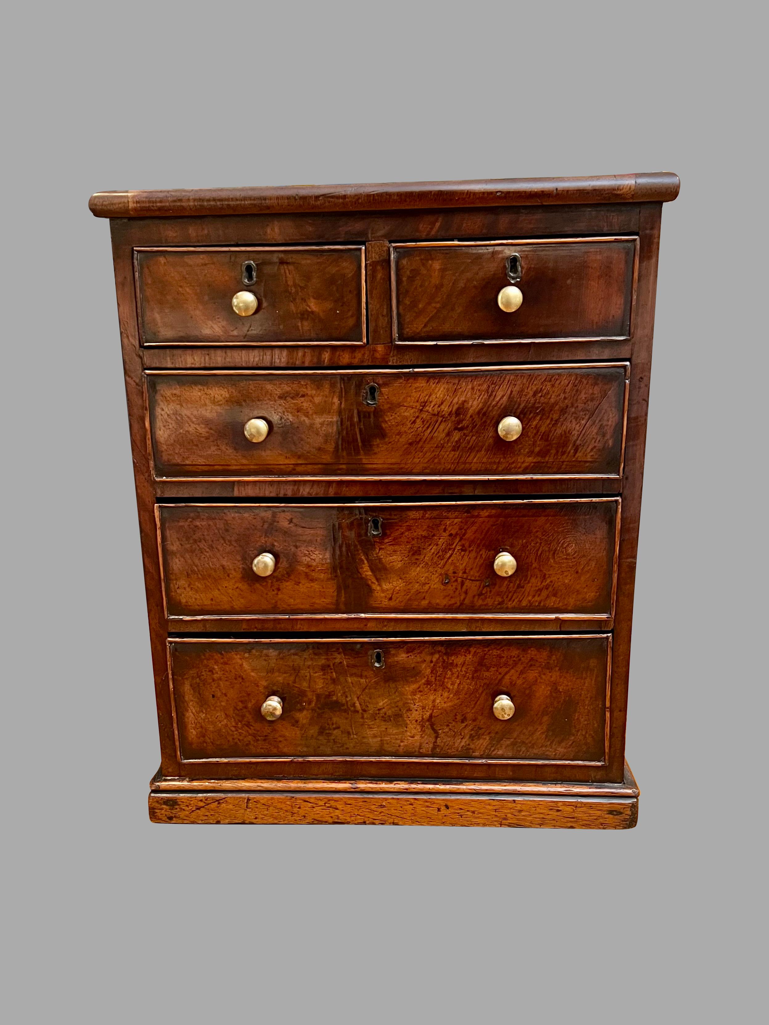 Cassettone inglese di buona qualità in mogano con 2 cassetti corti e 3 lunghi, ognuno dei quali conserva i pomelli originali in ottone e poggia su una base a plinto. Colore molto attraente e  per le facce dei cassetti e per il piano. Circa 1840-1850.