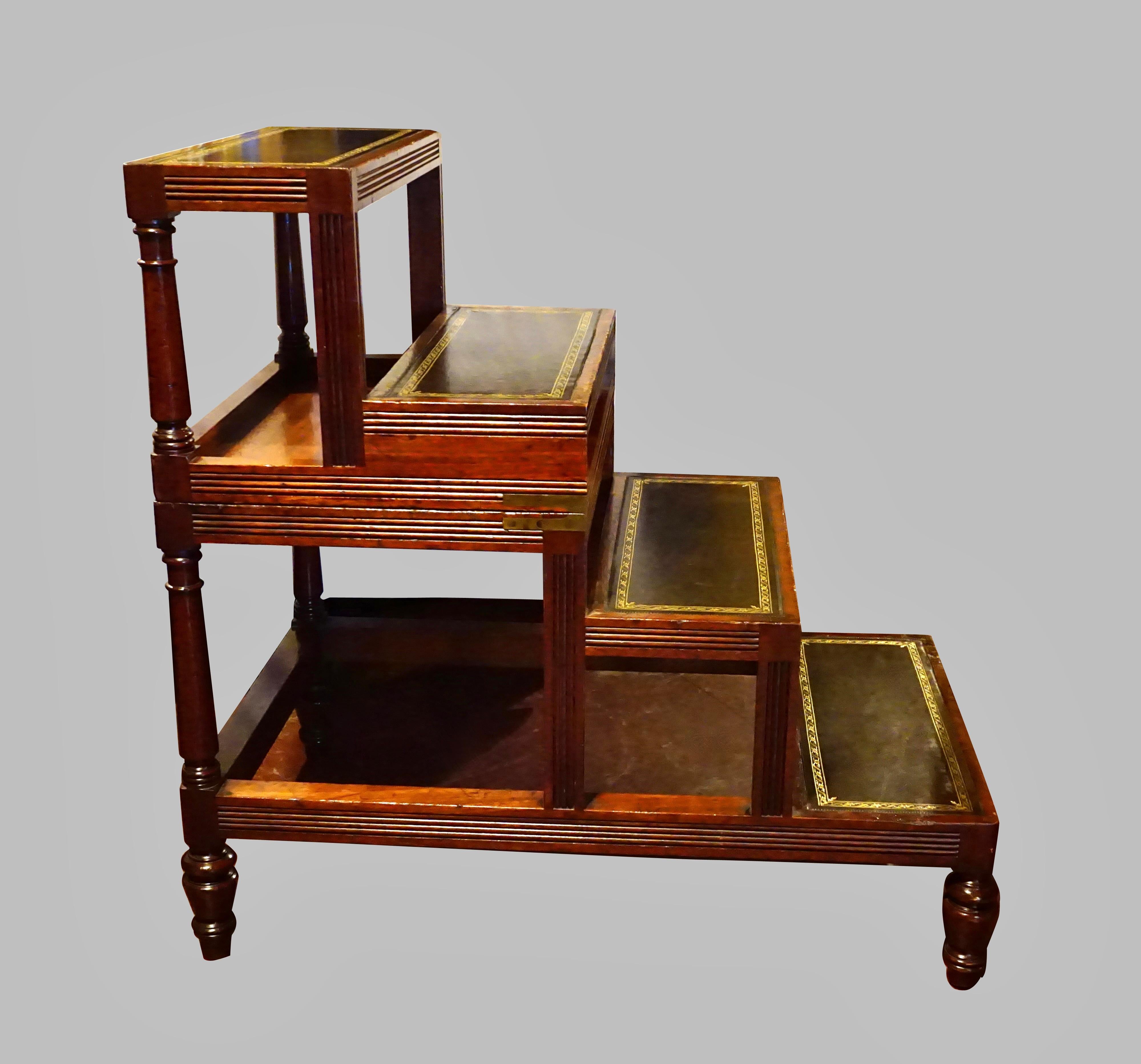 An English mahogany Regency style metamorphic library table with a brown tooled leather top opening to become a set of library stairs with 4 gilt-tooled leather treads supported on turned legs. This type of metamorphic furniture is practical and