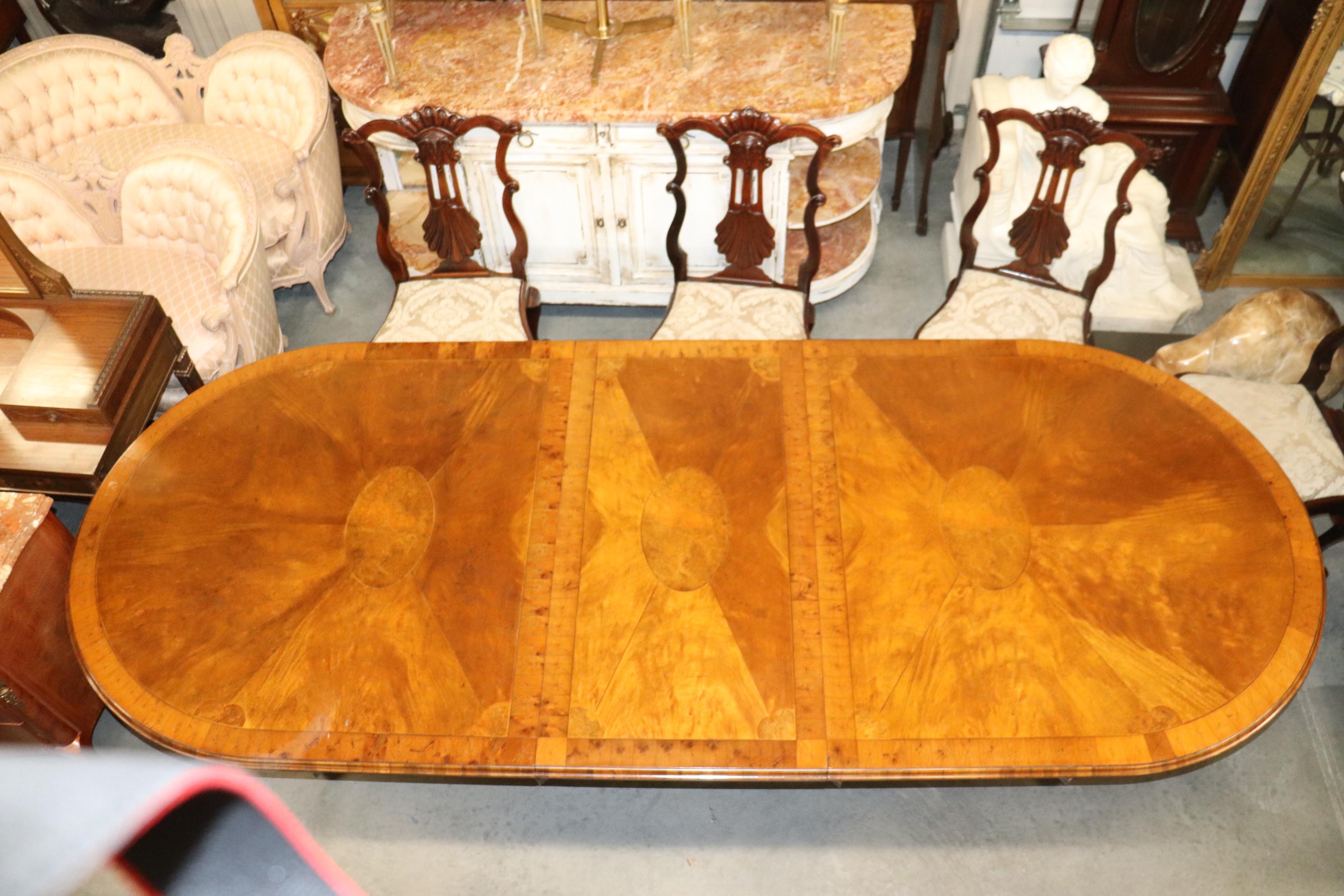 This gorgeous oyster burled dining table with two leaves and beautiful brass adorned legs. The table is in its original finish and has only the most minor imperfections from age and use. This is a custo-made hand-made table from England and measures