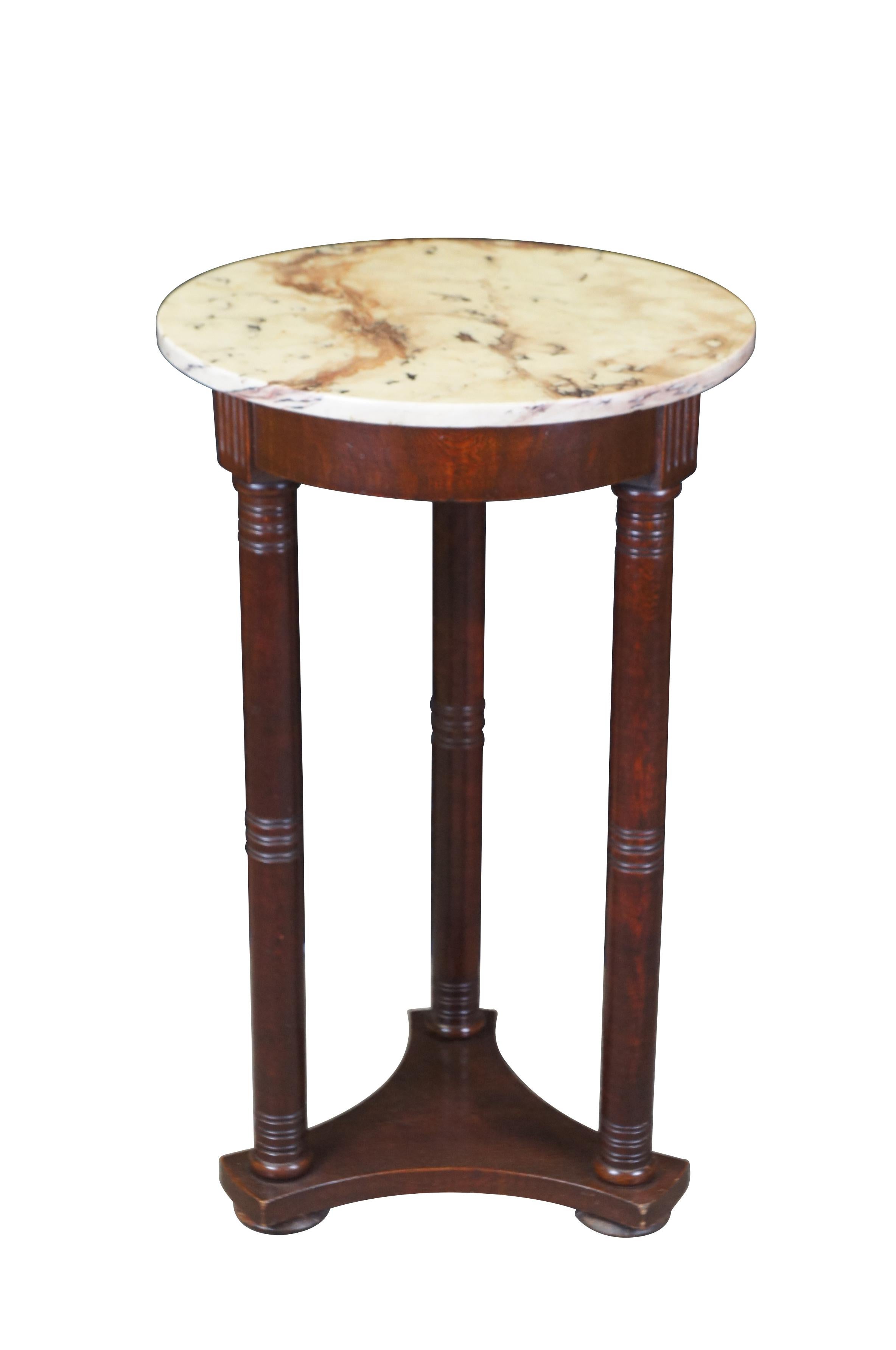 Vintage English Regency / George III style pedestal table.  Made of mahogany featuring triangular base supporting turned columns and round marble top.

Dimensions:
17.75