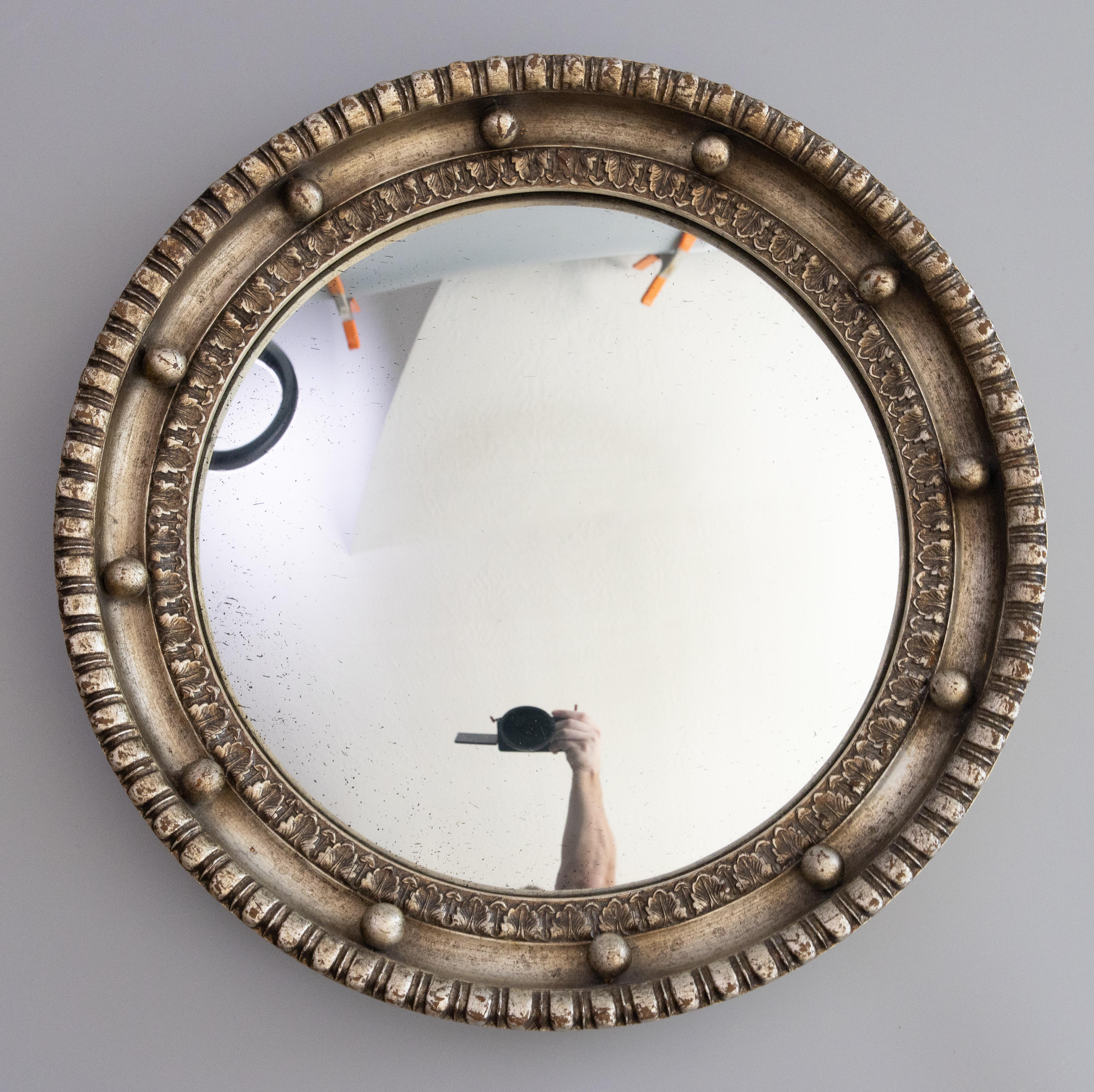 A superb early Regency style bullseye silver gilt wood mirror from England, circa 1930. This stunning mirror retains the original convex mirror glass and has decorative spheres, gadrooning, and acanthus leaf details in a lovely silvered patina. It's