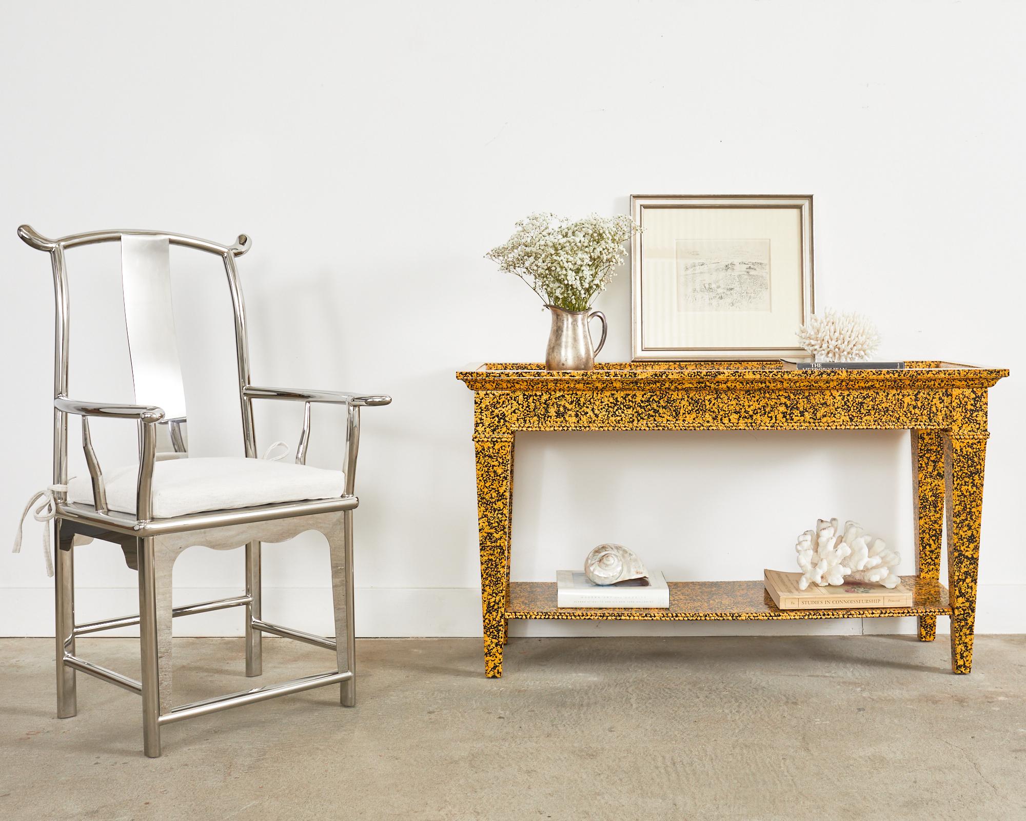 Whimsical lacquer speckled console table or sofa table by artist Ira Yeager (American 1938-2022). The two-tier table features a brilliant mustard yellow lacquered finish over a black ground painstakingly painted by Ira. The speckled finish has a