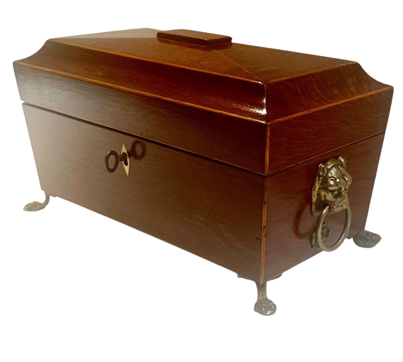 A distinguished English Regency tea caddy, likely dating to the 1830s, featuring a red leather lined interior and a velvet bottom. The caddy retains its original twin tea holders and comes with its original key.

The design is enhanced with detailed