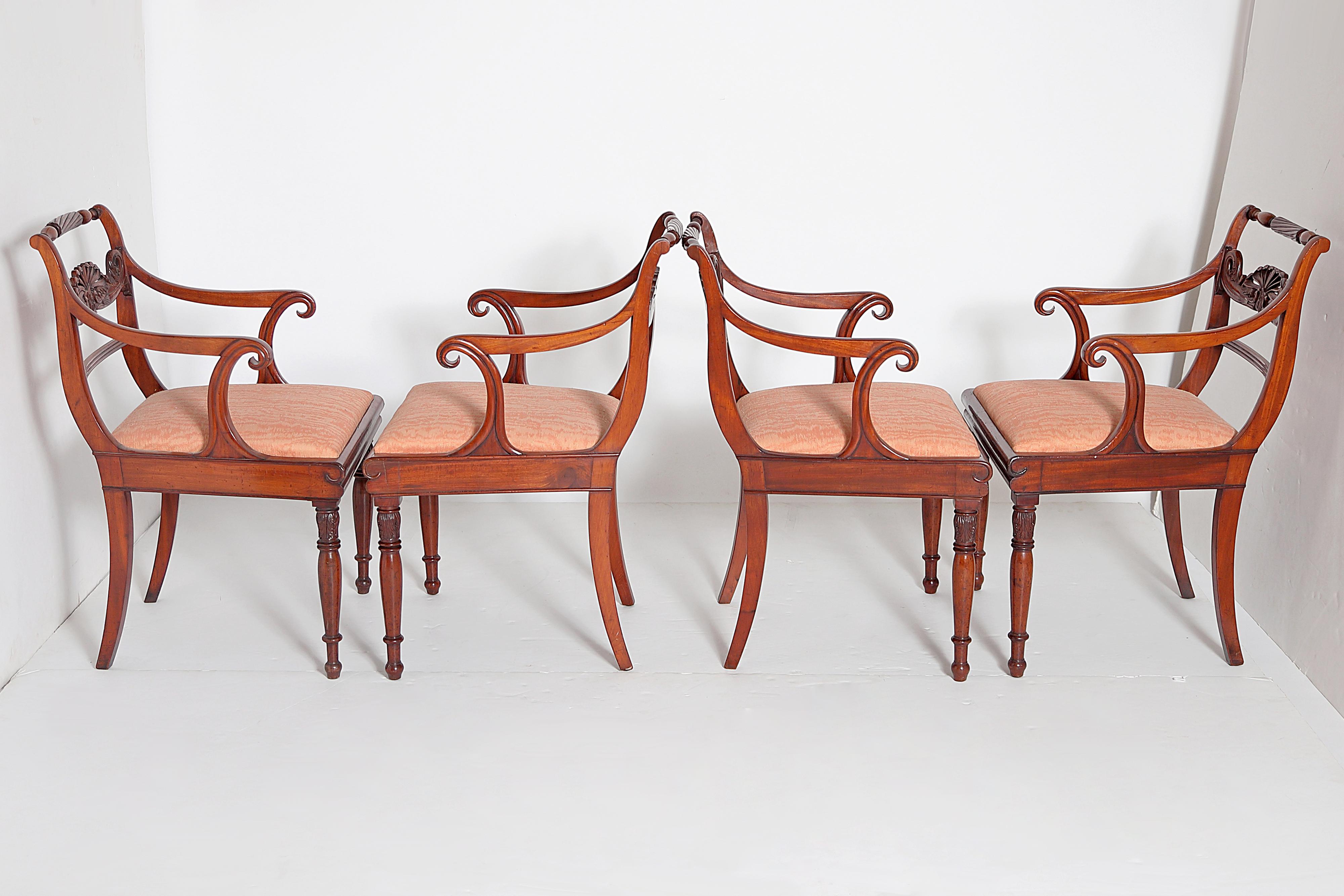 A set of eight (8) English Regency armchairs / dining chairs, Trafalgar design with turned rope twist crest rail and central carved anthemion / palmette back splat with dolphins each side, curvy / shaped armrests, inlaid ebony and boxwood stringing