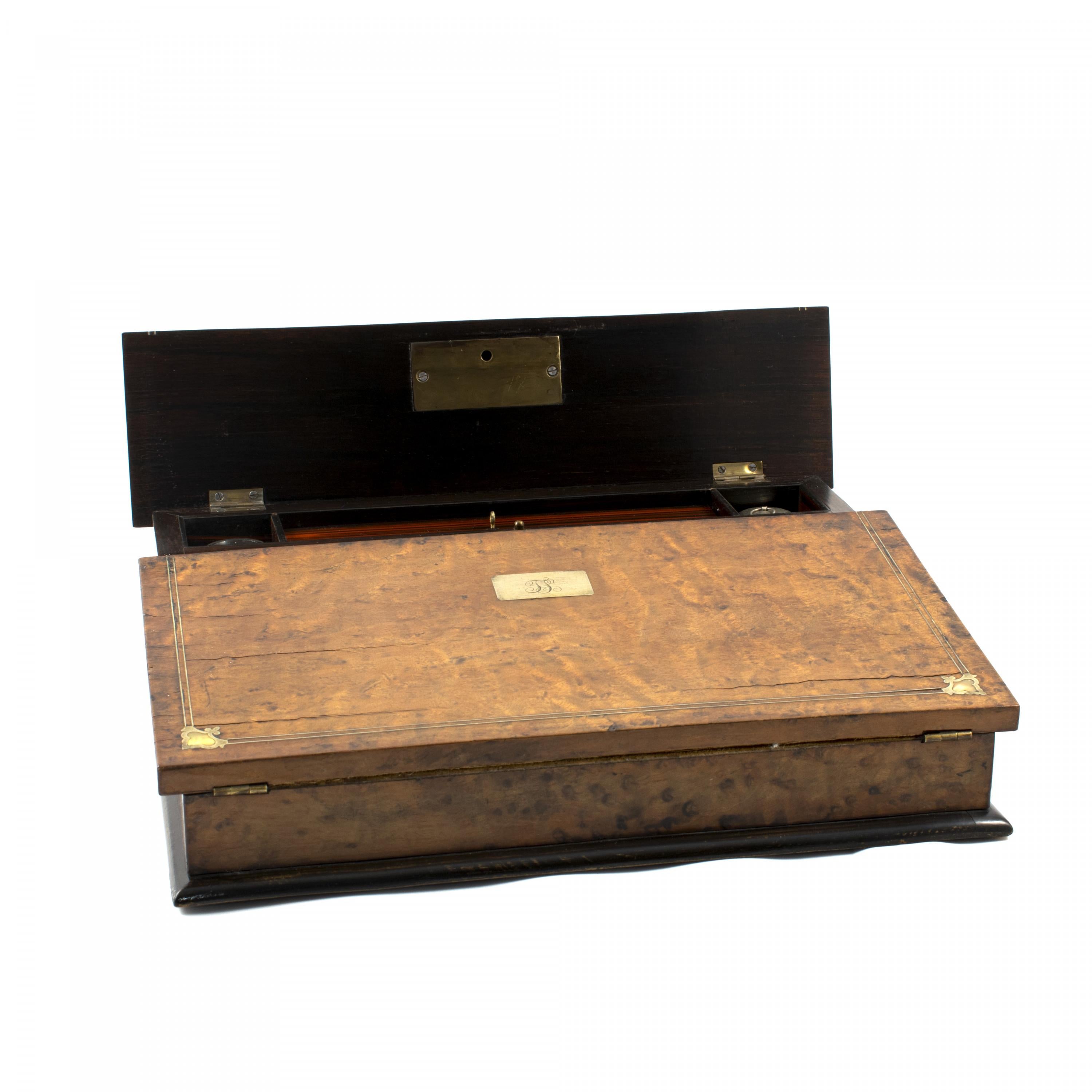 English writing slope in bird's-eye maple.
The box can be opened to create a sloping desk pad covered with (original) fabric.
Inside a fitted interior of compartments for storing ink wells, pens, papers or similar.
Outer main area with mother of
