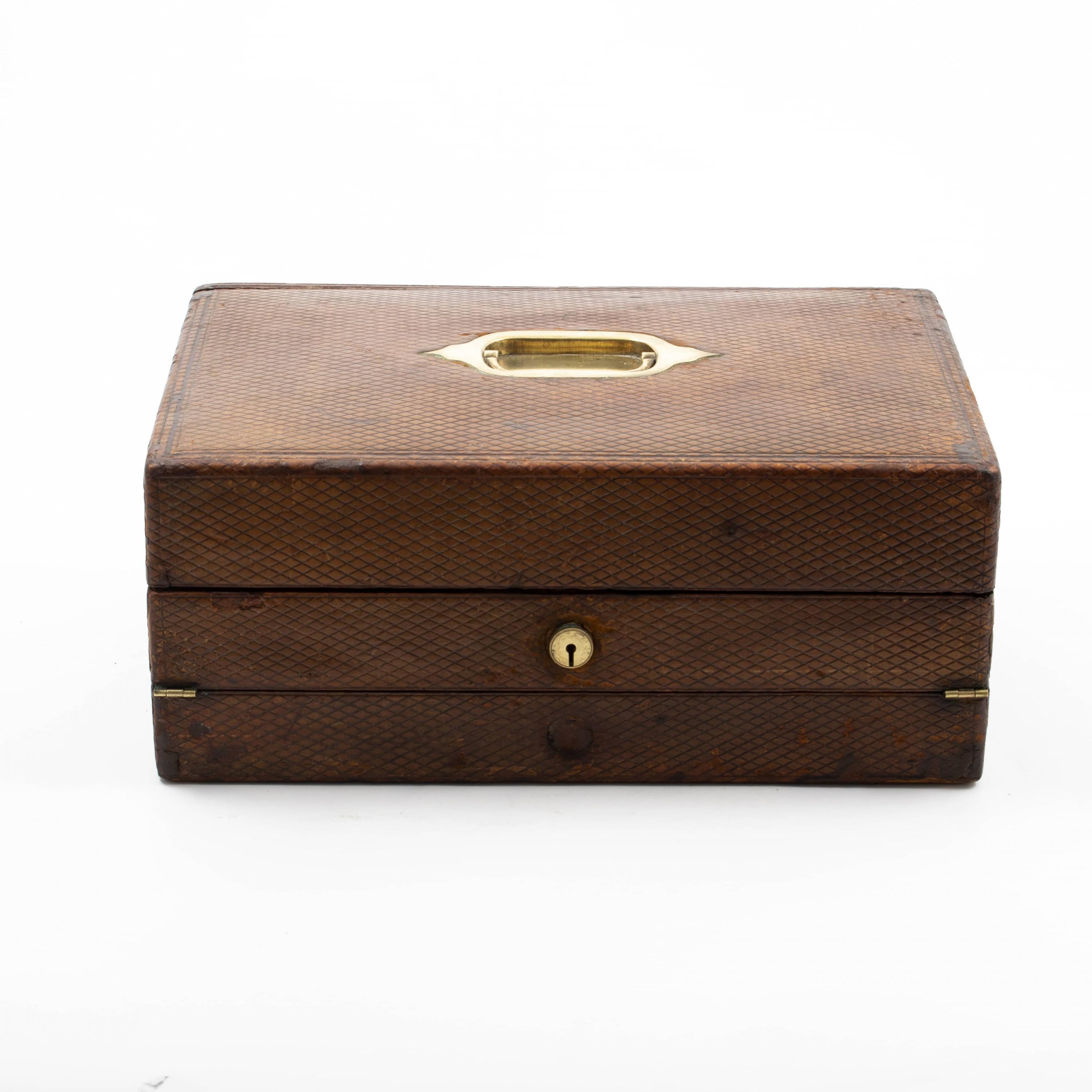 Rare regency travelling writing slope / nécessaire de voyage of outstanding quality.
Wooden box, the exterior dressed in brown leather, bound and embossed with diamond shaped pattern. Top fitted with a brass handle.
The lid opens to reveal a black