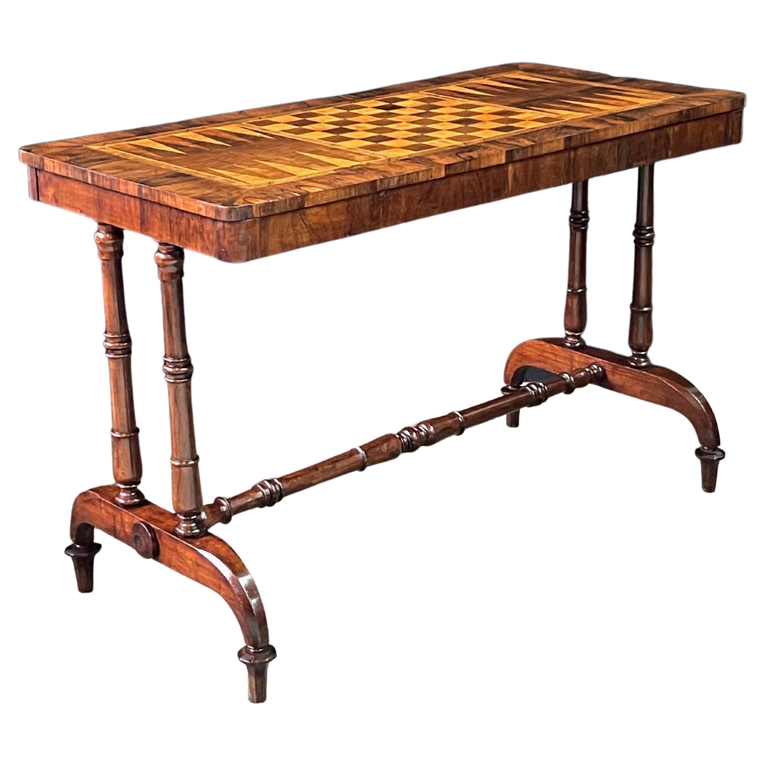 Stunning 19th century English game table in the Regency style with a rectangular top finely inlaid of exotic woods. Centered on the table is a chess/checkerboard that is flanked by backgammon boards. A beautifully-turned mahogany trestle base on