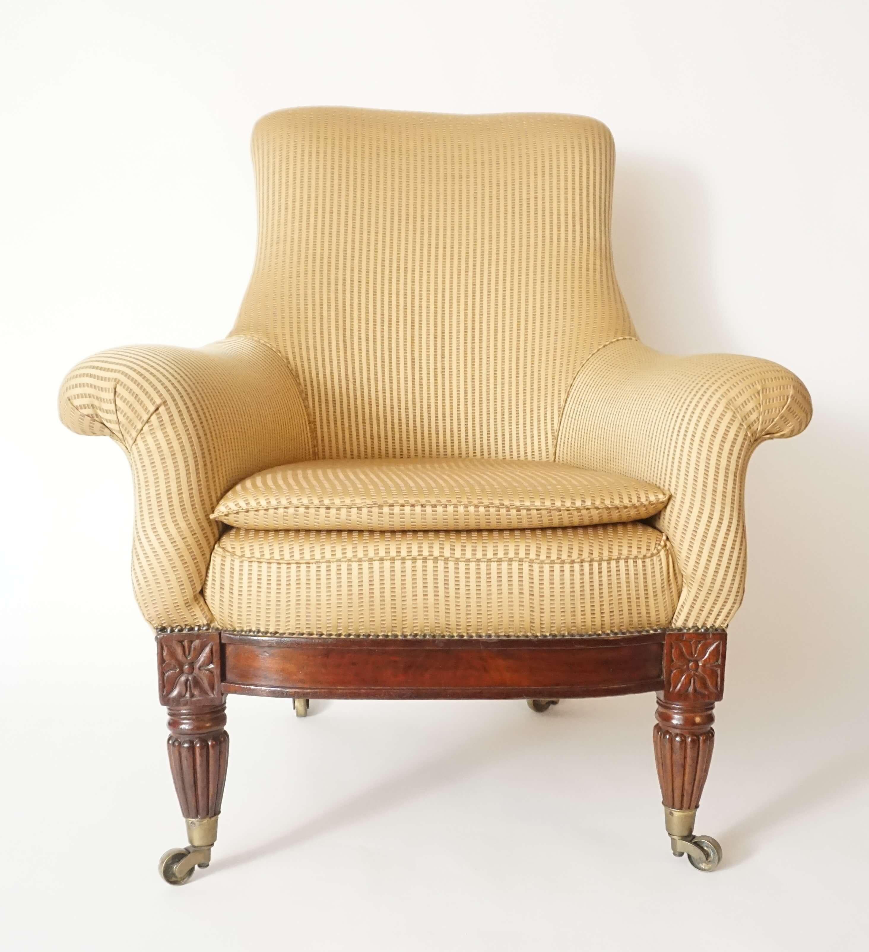Circa 1830 George IV / William IV English Regency armchair of large size having upholstered frame with rectangular back issuing outward scrolling arms either side of D-shaped seat with slip-cushion above bowed mahogany seat-rail connecting carved