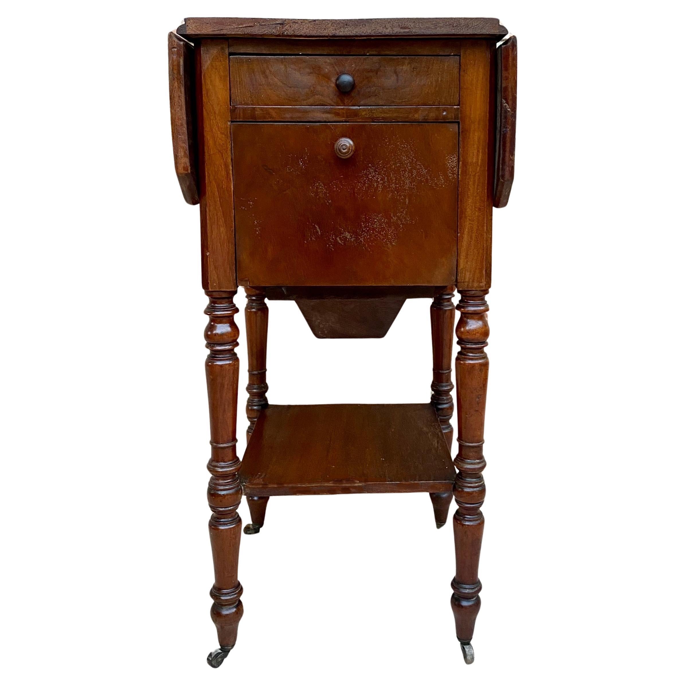 English side table with walnut wood wings.
Lacquered with drawer and folding door on one side that have wooden handles and door.
A very good quality Regency period baby walnut table which has its well preserved top with flap on each side and a small