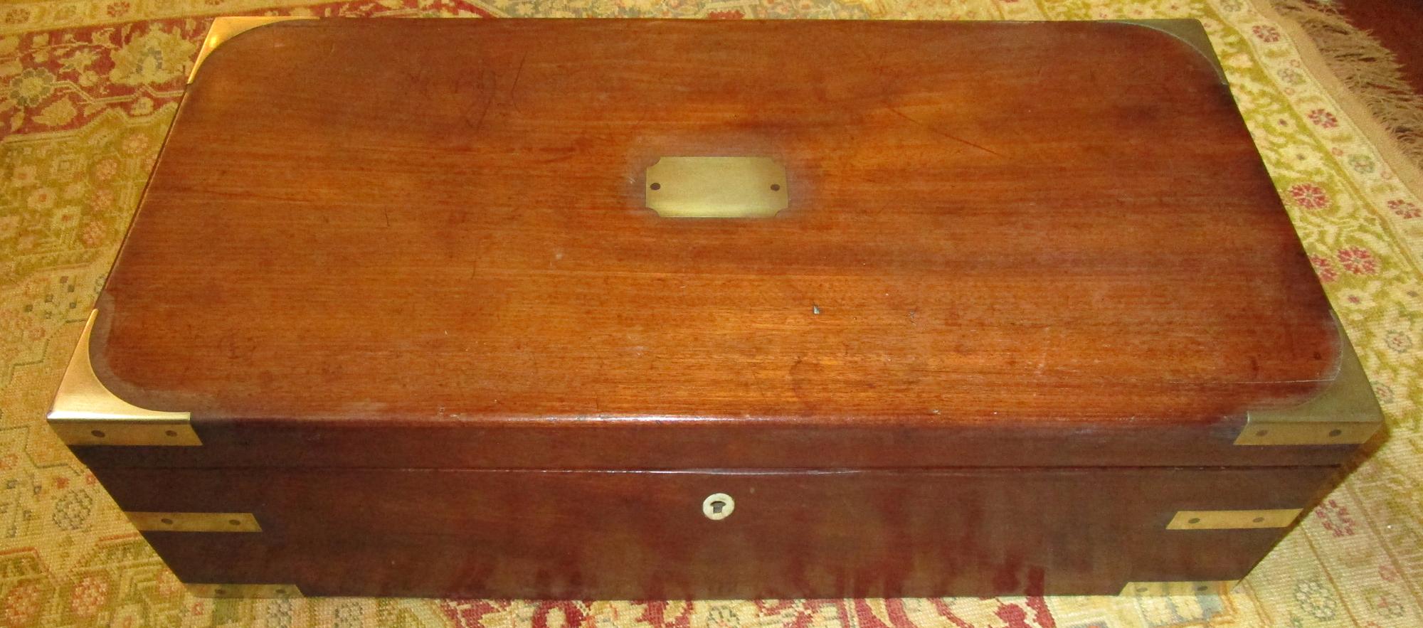 English Regency walnut travelling sloped lap desk box with brass corner mounts and retractable handles. Bone escutcheon lock (no key.) Other features include Fine tooled leather insert and a secret spring loaded compartment inside -see last two