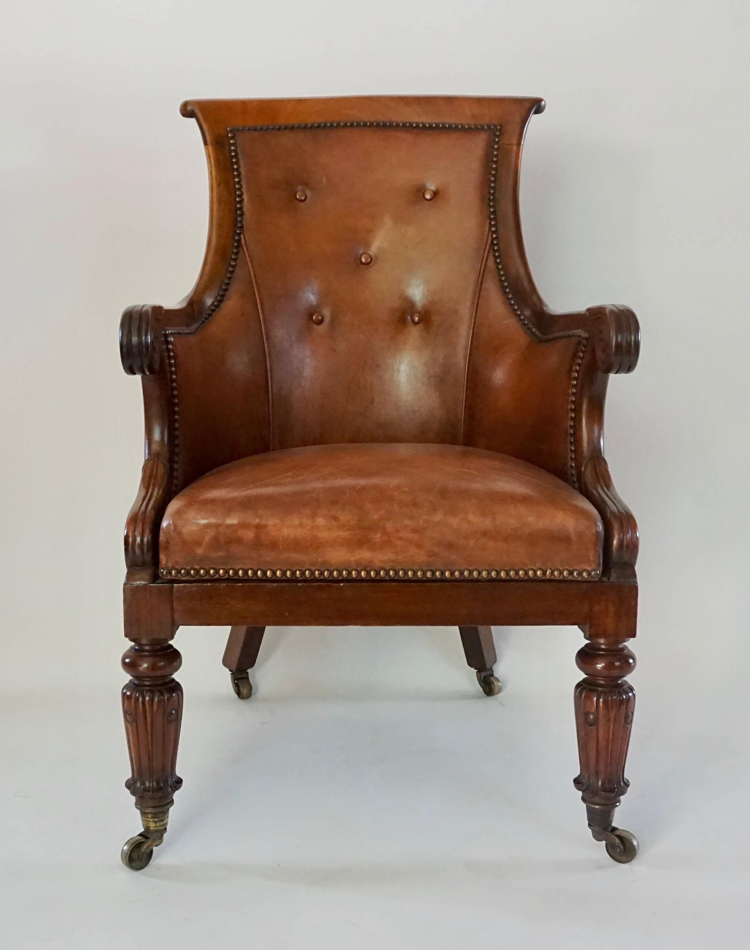 Elegant circa 1835 late English Regency period neoclassical bergère or armchair having mahogany frame and leather upholstery; the curved scrolled crestrail joining stiles continuing into acanthus-capped arms and concave supports around D-shaped