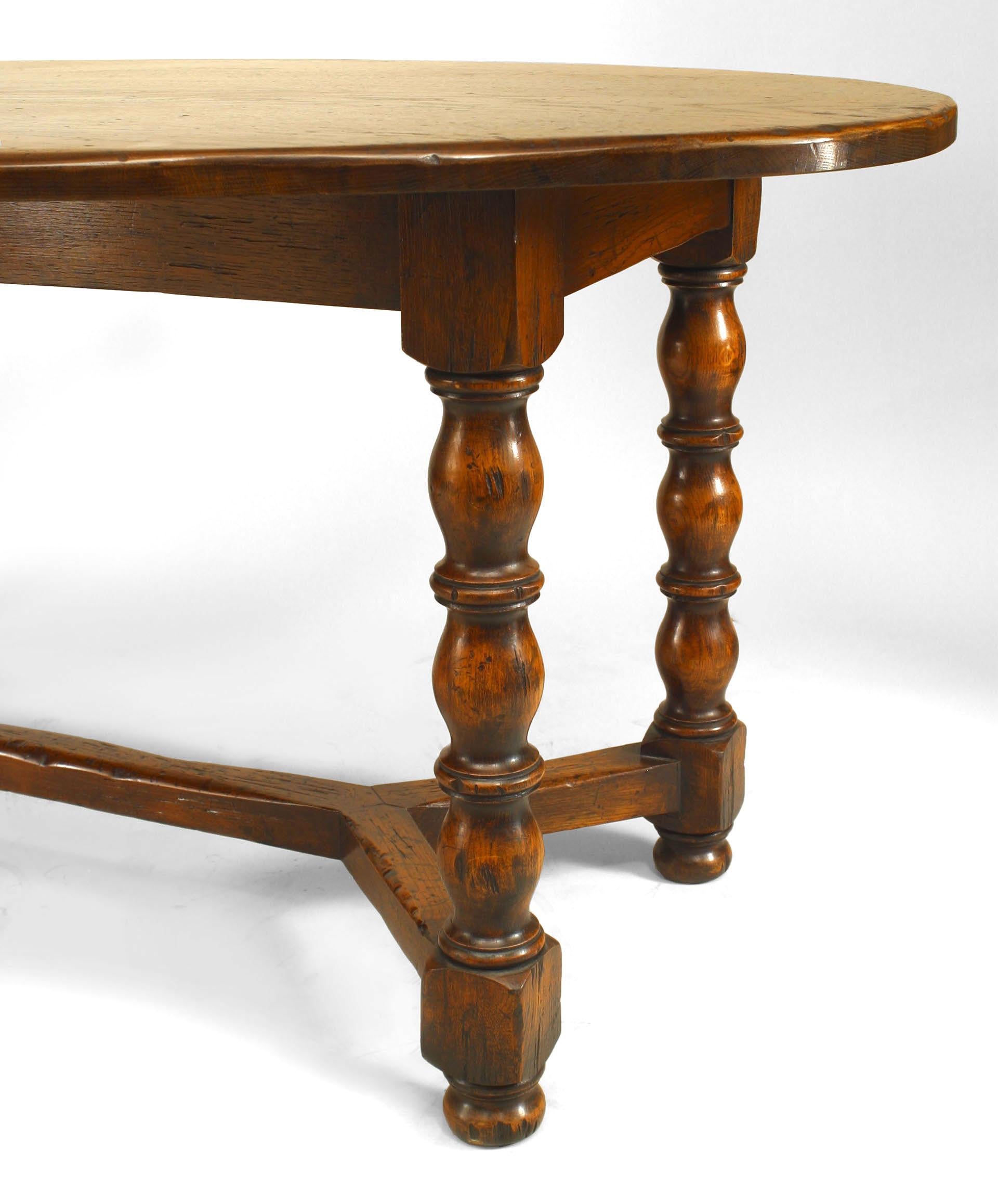 English Renaissance style (20th Century) oak refectory table with oval top and stretcher.
