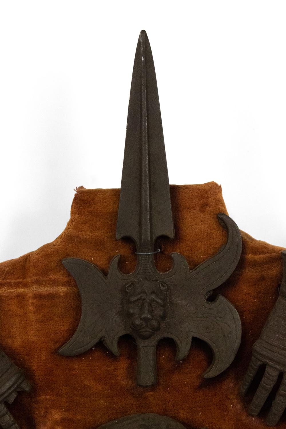 Plaque murale en forme de blason miniature en forme de bouclier de style Renaissance anglaise (20e siècle) avec lances et armures en métal sur support en velours marron.