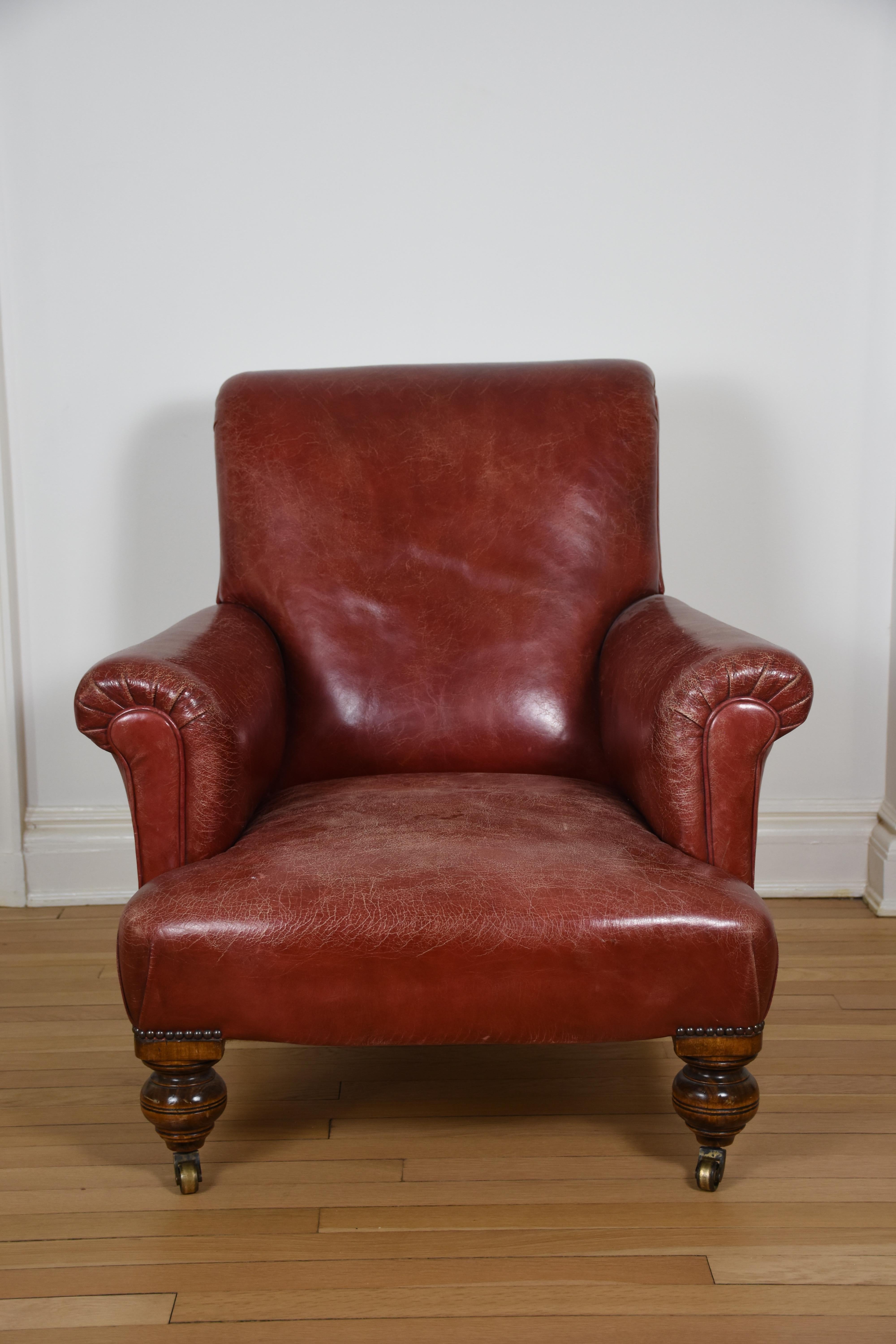 Ce fauteuil classique anglais à accoudoirs roulants allie une élégance intemporelle à un confort exceptionnel. Revêtue d'un riche cuir rouge patiné, cette chaise respire le caractère et la sophistication. Les accoudoirs légèrement enroulés et