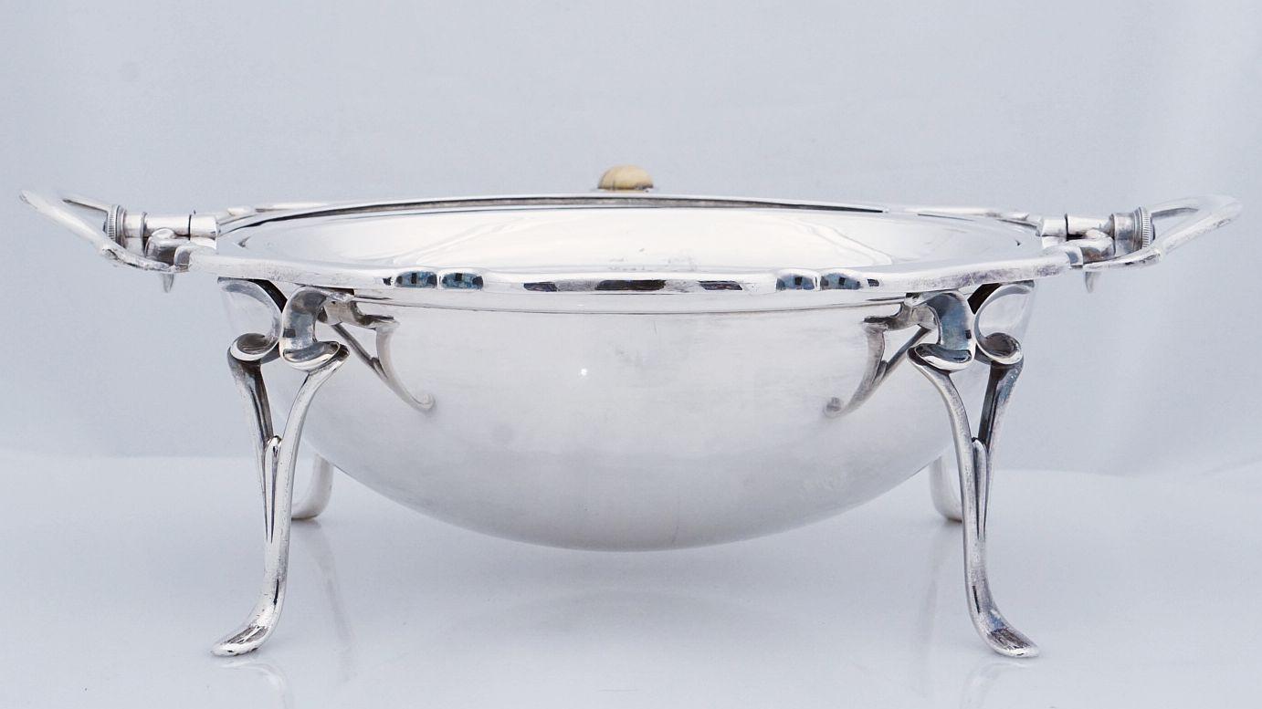 A handsome English roll-over dome top tureen or serving dish of fine English silver-plate, featuring a pierced oval interior tray with fitted undertray, both removable for cleaning, resting on cabriole legs.

Impressed marks to base.


