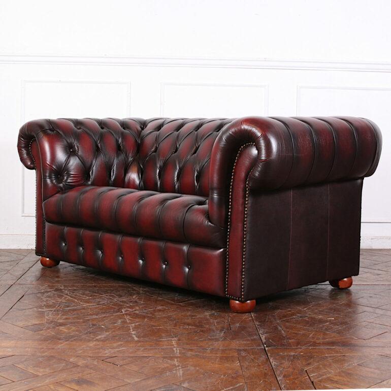 English-made vintage rolled-arm button-tufted ox blood leather loveseat or sofa.

