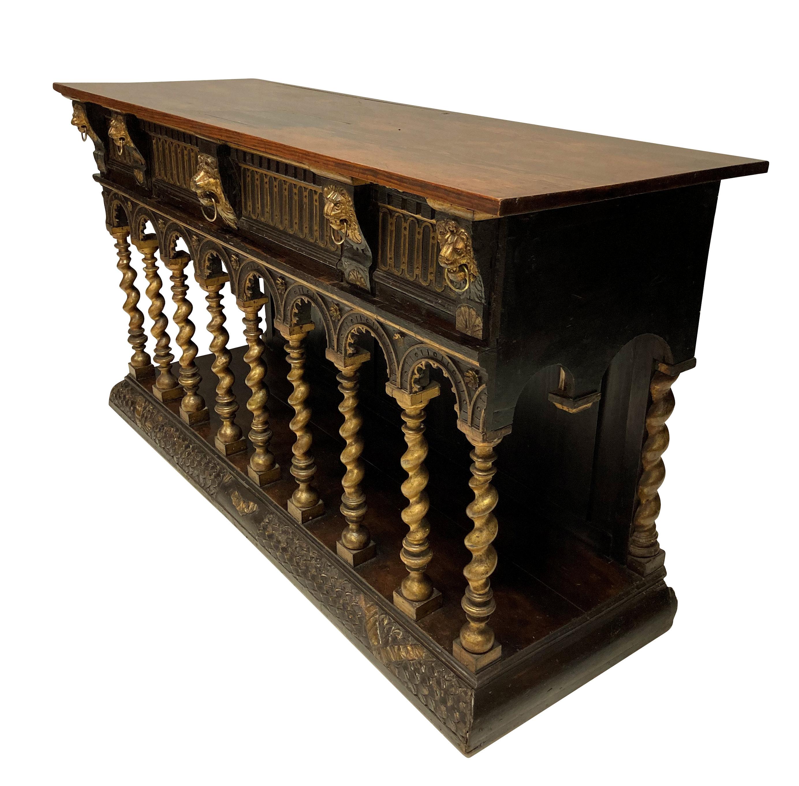 An unusual English sideboard or console in the Romanesque manner, modelled on a Church Altar. Of oak, walnut and parcel-gilt, with single frieze drawer. This item is in the manner of William Burges' furniture, to be found in museums around the