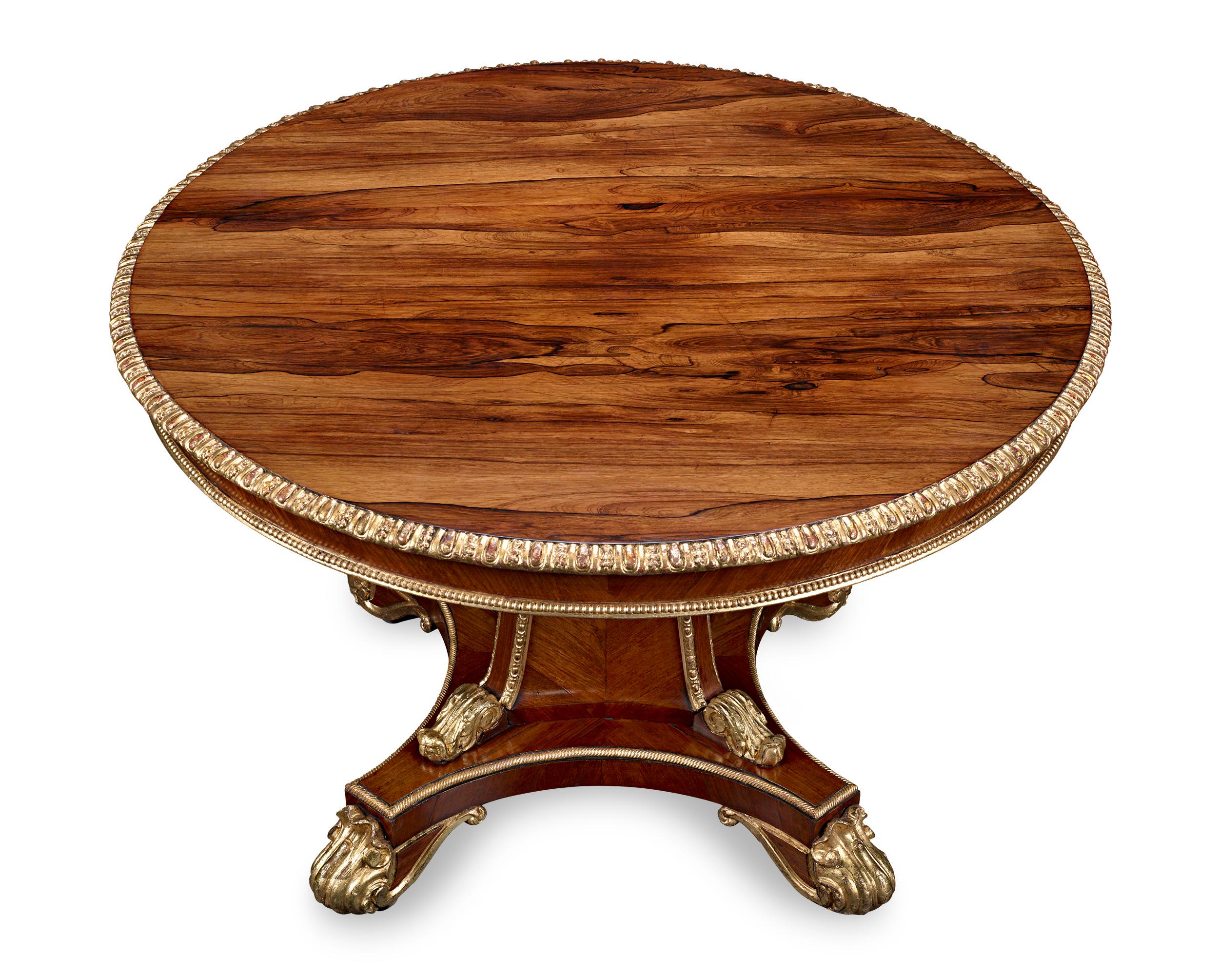 Blending form and function, this handsome rosewood center table is an extraordinary example of superior British craftsmanship. Rosewood furniture became popular with the wealthy during England's Regency period because of its natural beauty and