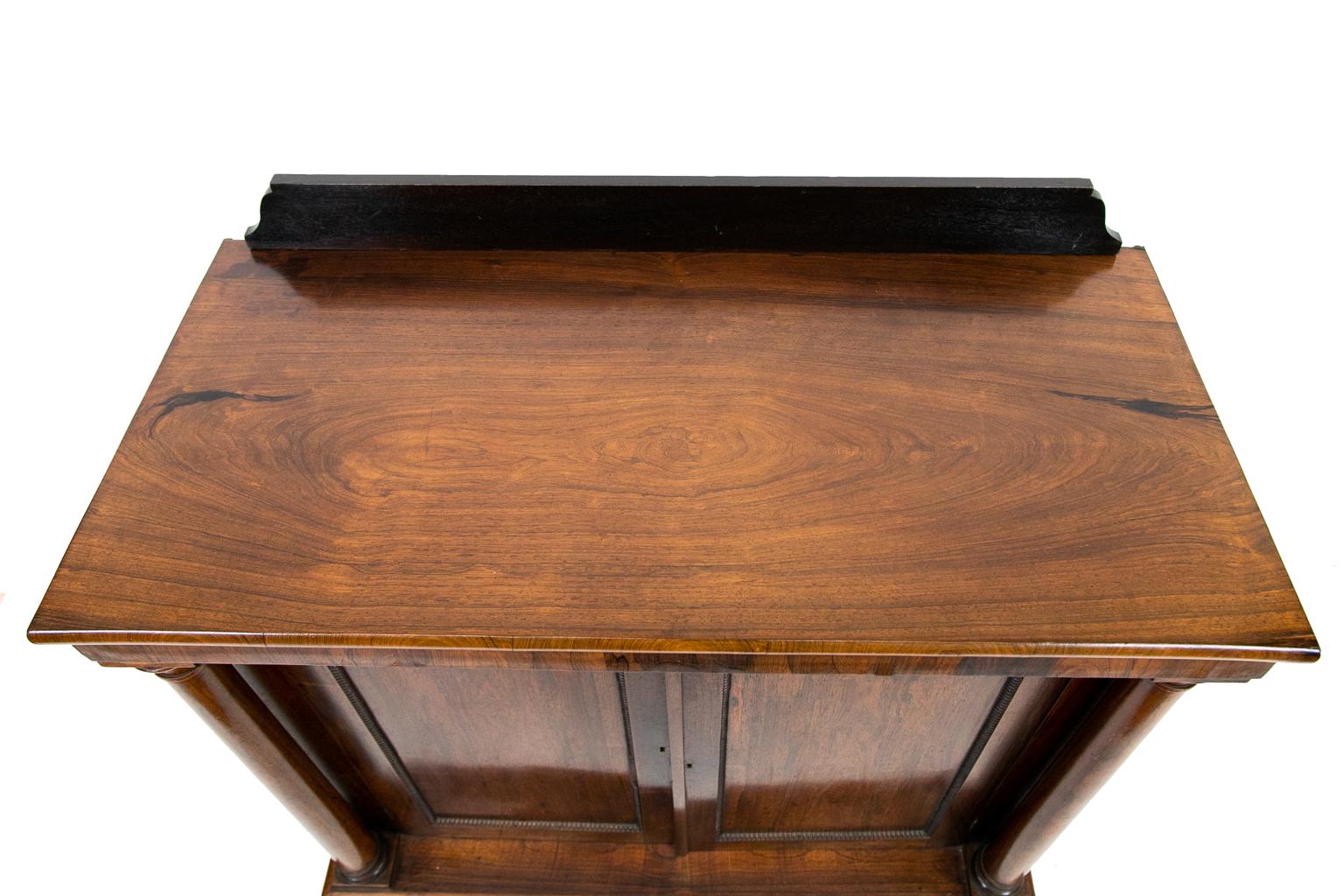 English rosewood console cabinet, has freestanding rosewood columns, while the doors have beaded molding. The feet are carved with reeding.
 