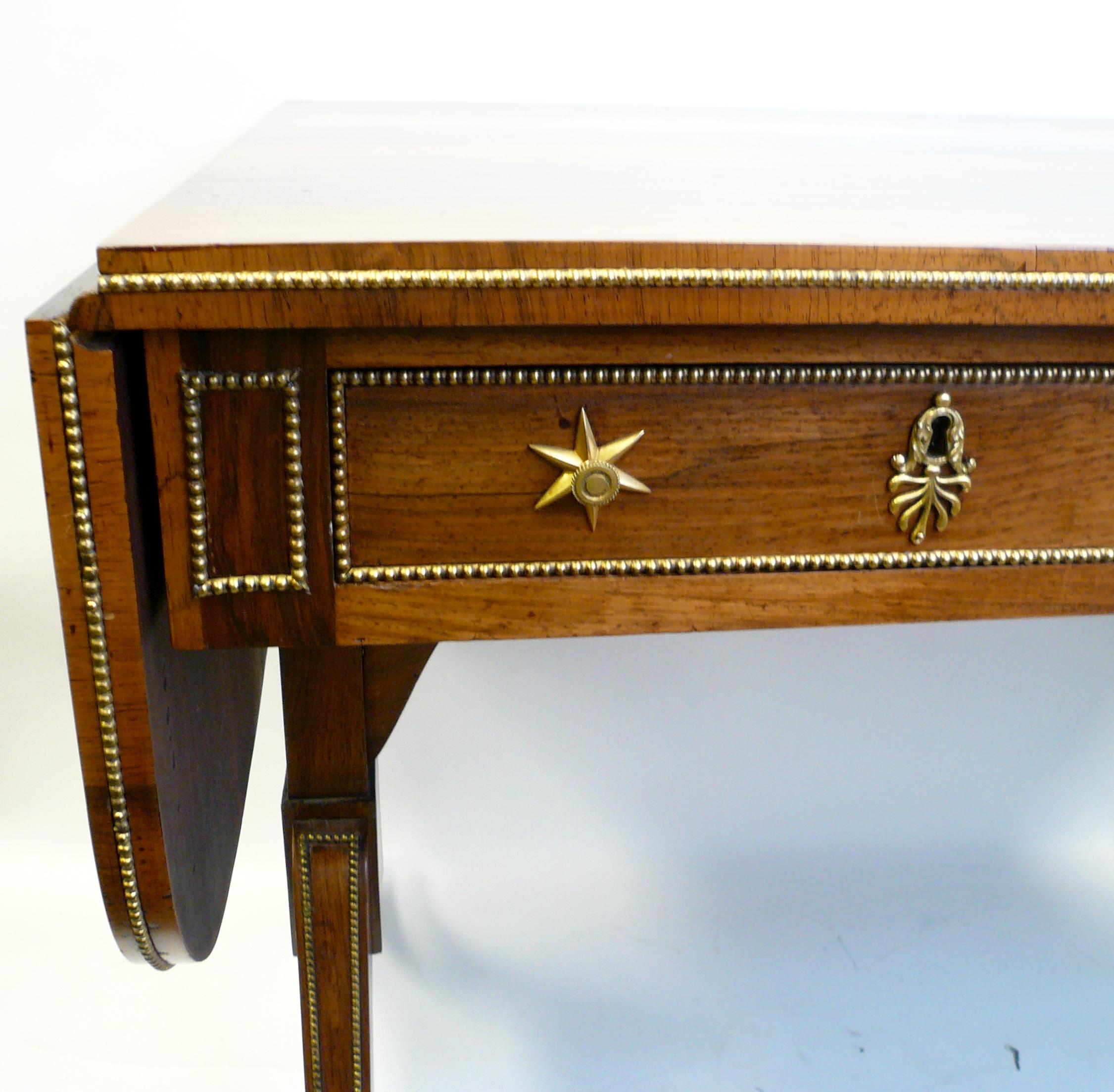 This exceptional Regency rosewood sofa table is beautifully made. Having well matched rosewood veneers and gilt brass mounts, it is attributed to Gillows of Lancaster. For related examples, see: Gillows of Lancaster and London by Susan E. Stuart,