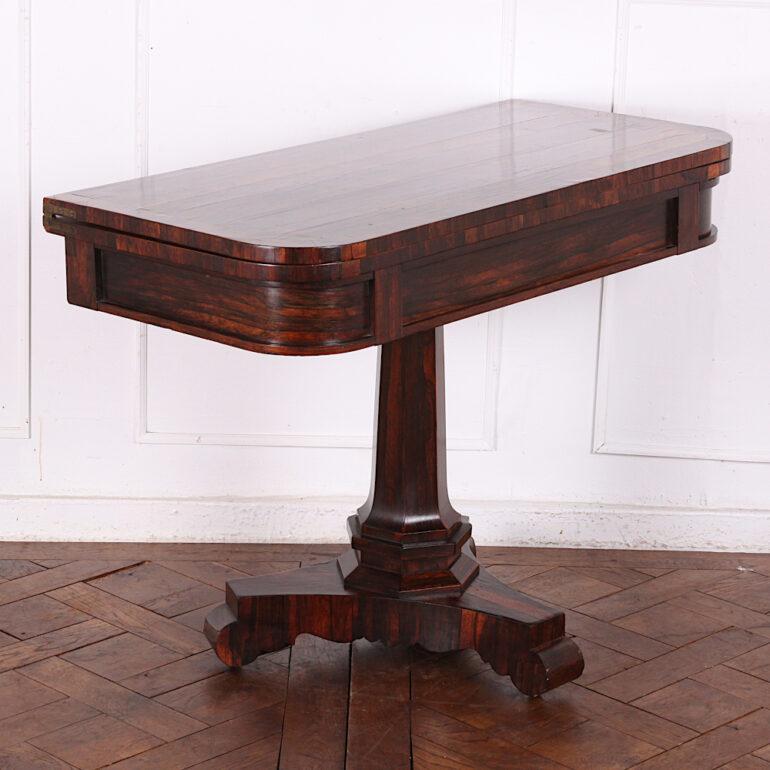 English Exotic wood ‘flip-top’ games table, raised on a pedestal support over trefoil base. C. 1840.
 