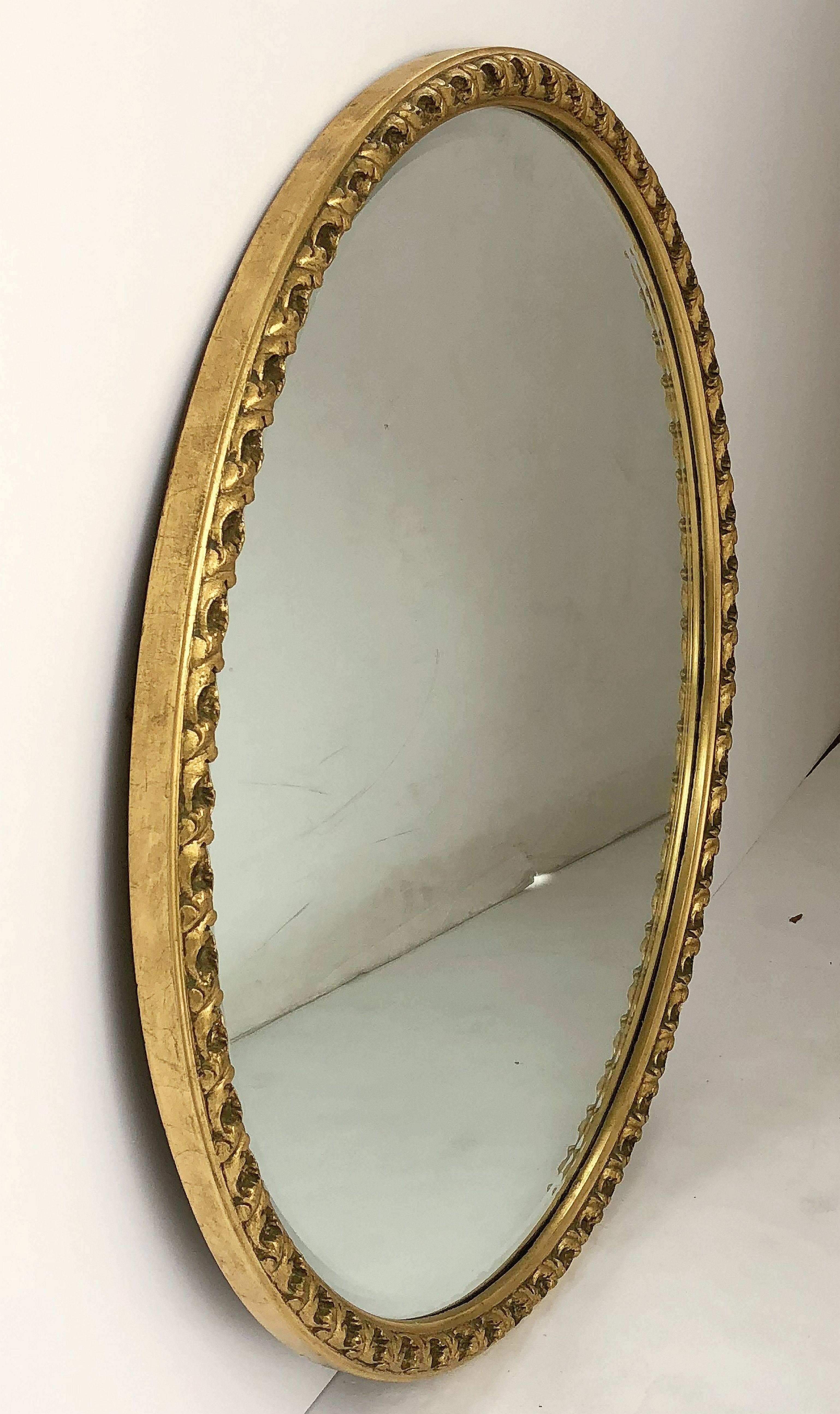 A fine English round bevelled mirror in a giltwood frame featuring a foliate design.

Measures: Diameter 25 1/2 inches.
