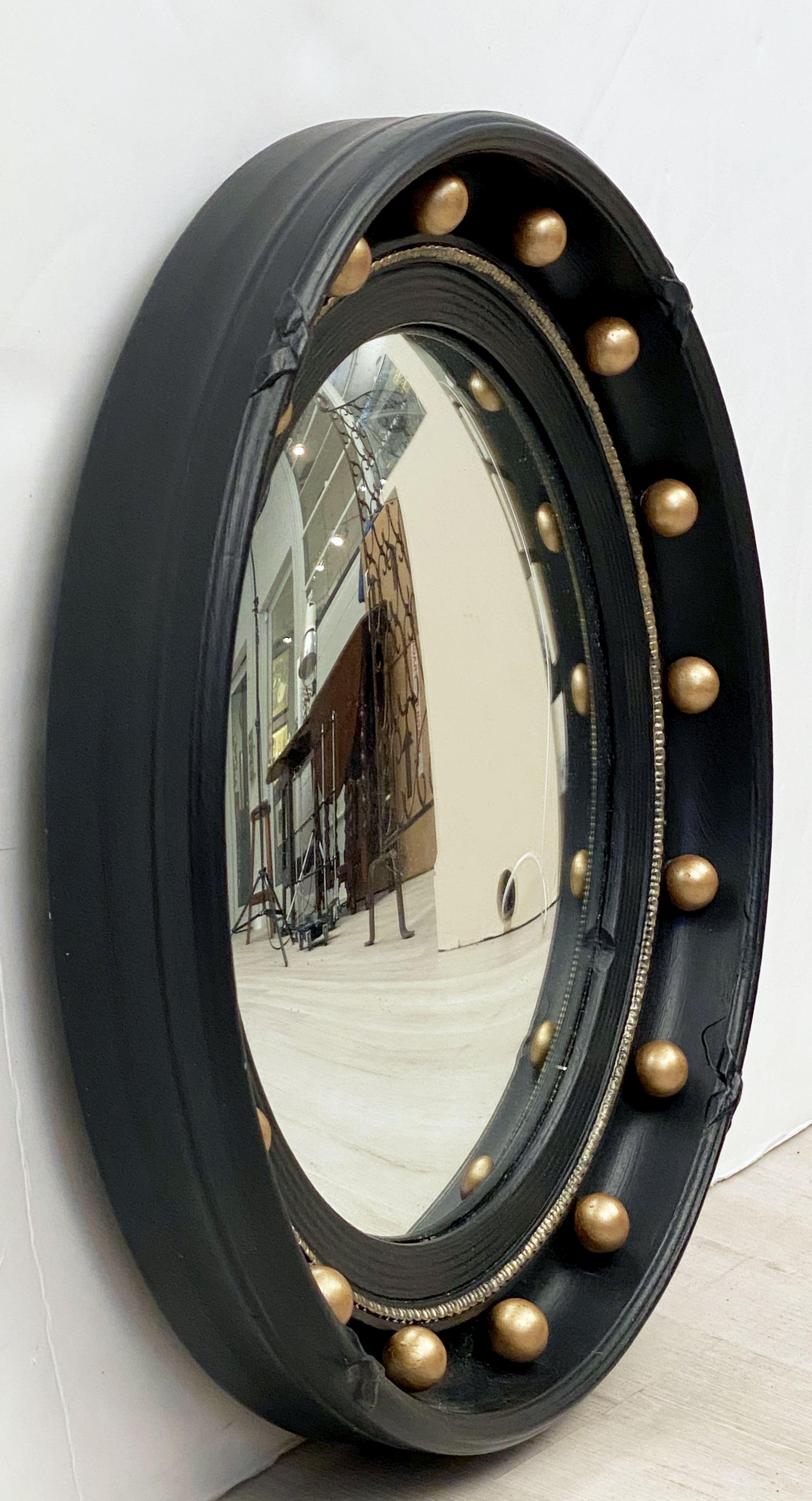 A fine English round convex mirror featuring a Regency design of a moulded, ebonized frame with gilt balls around the circumference.

Diameter is 16 1/4 inches.