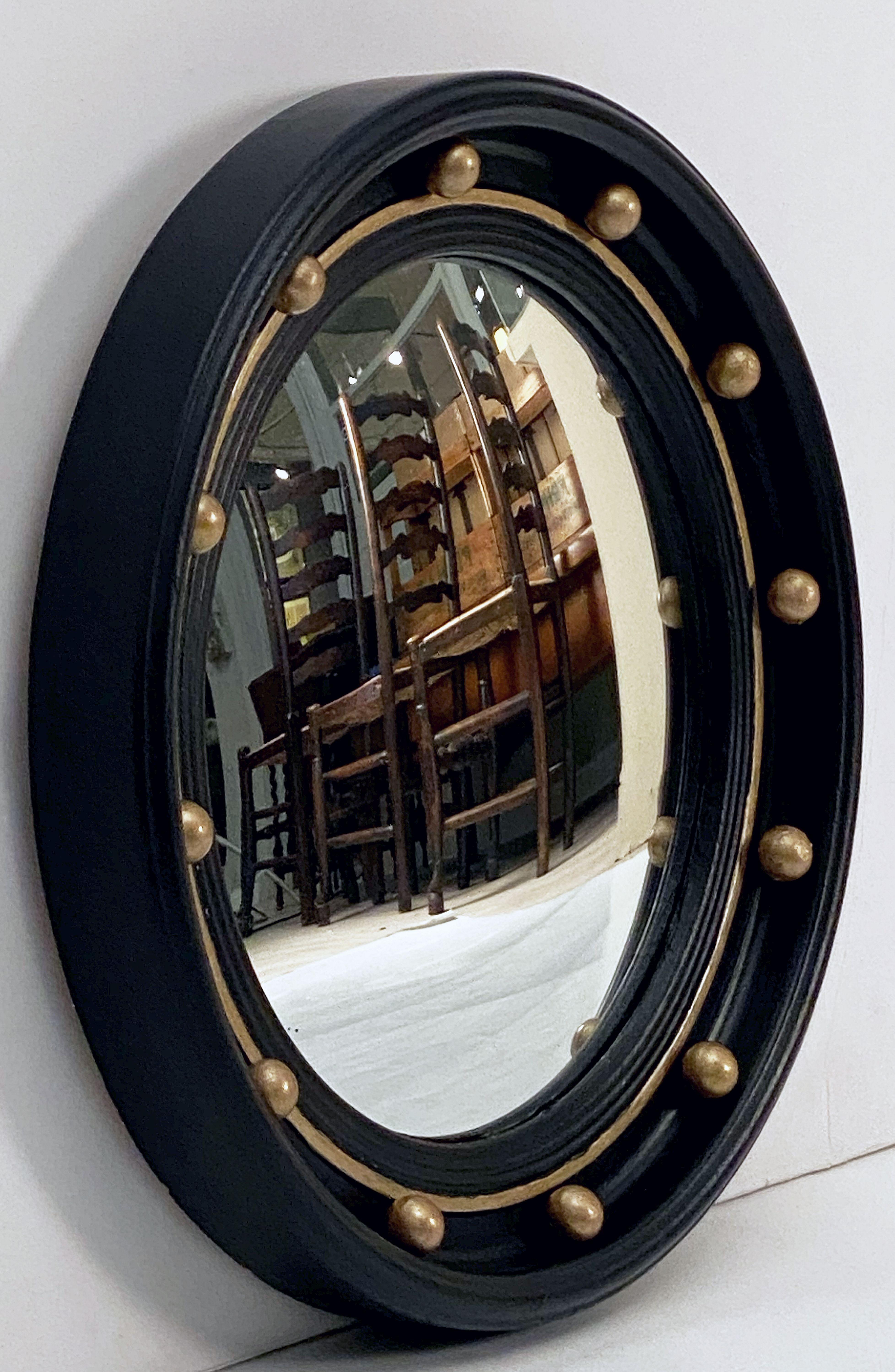 A fine English round or circular convex mirror featuring a Regency design of a molded, ebonized frame with gilt balls and gilt accents around the circumference.

Measures: Diameter is 16 1/4 inches.