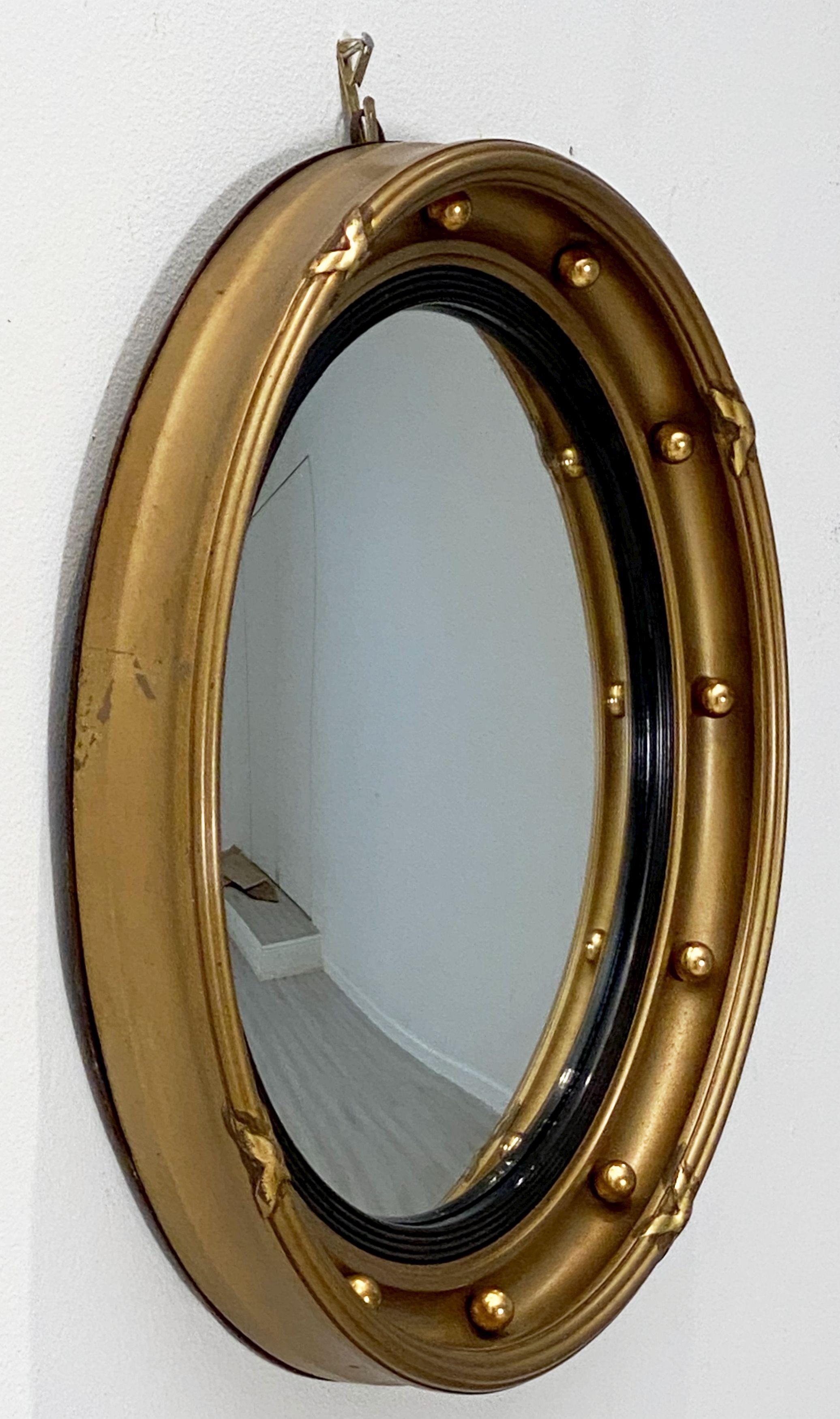 A fine English round or circular convex mirror featuring a Regency design of a moulded gilt frame and ebonized trim, with gilt balls around the circumference.

Dimensions: Diameter 15 3/4 inches x Depth 2 1/8 inches