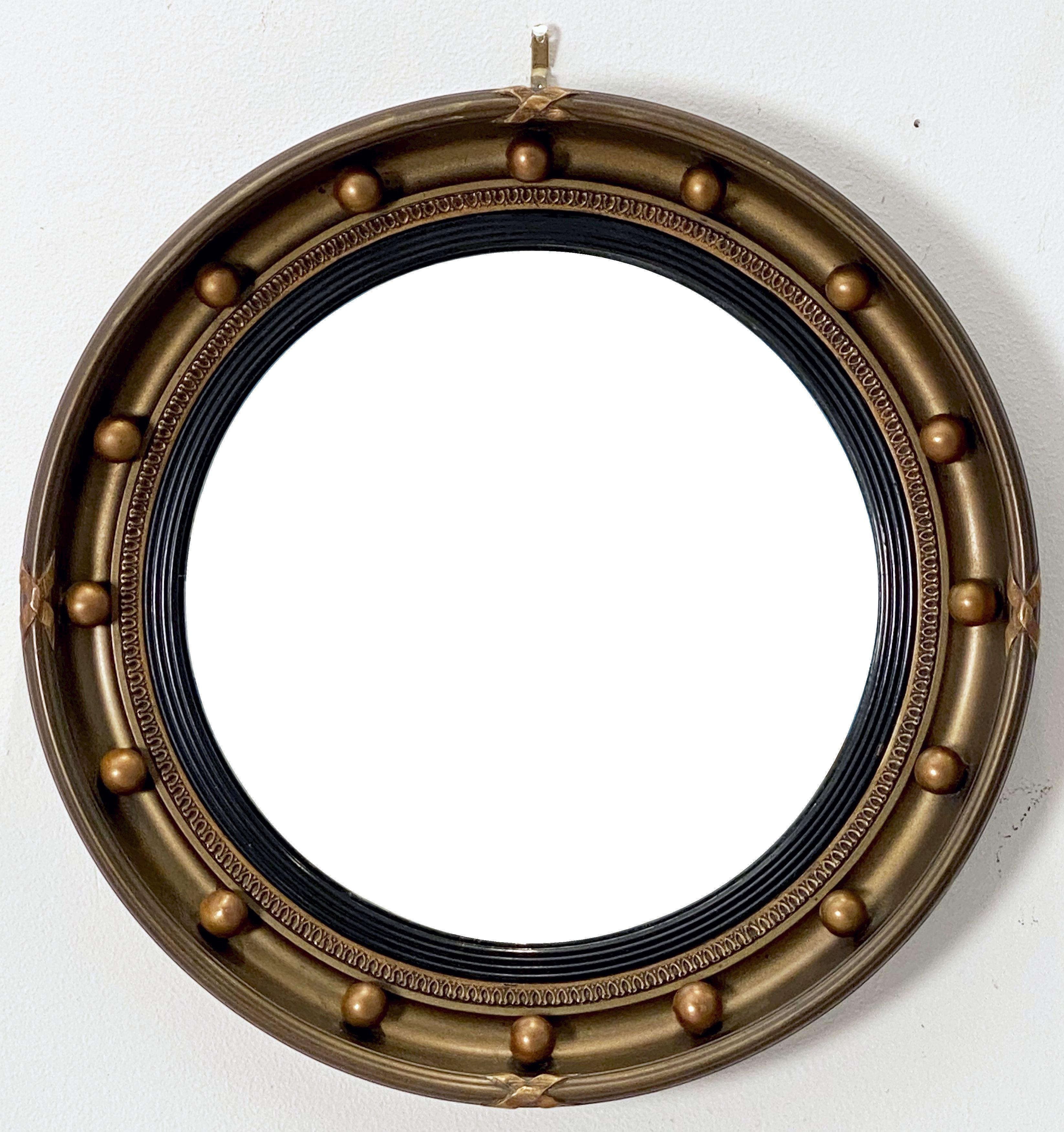 A fine English round or circular convex mirror featuring a Regency design of a moulded gilt frame and ebonized trim, with gilt balls around the circumference.

Dimensions: Diameter 16 1/2 inches x depth 2 1/2 inches.