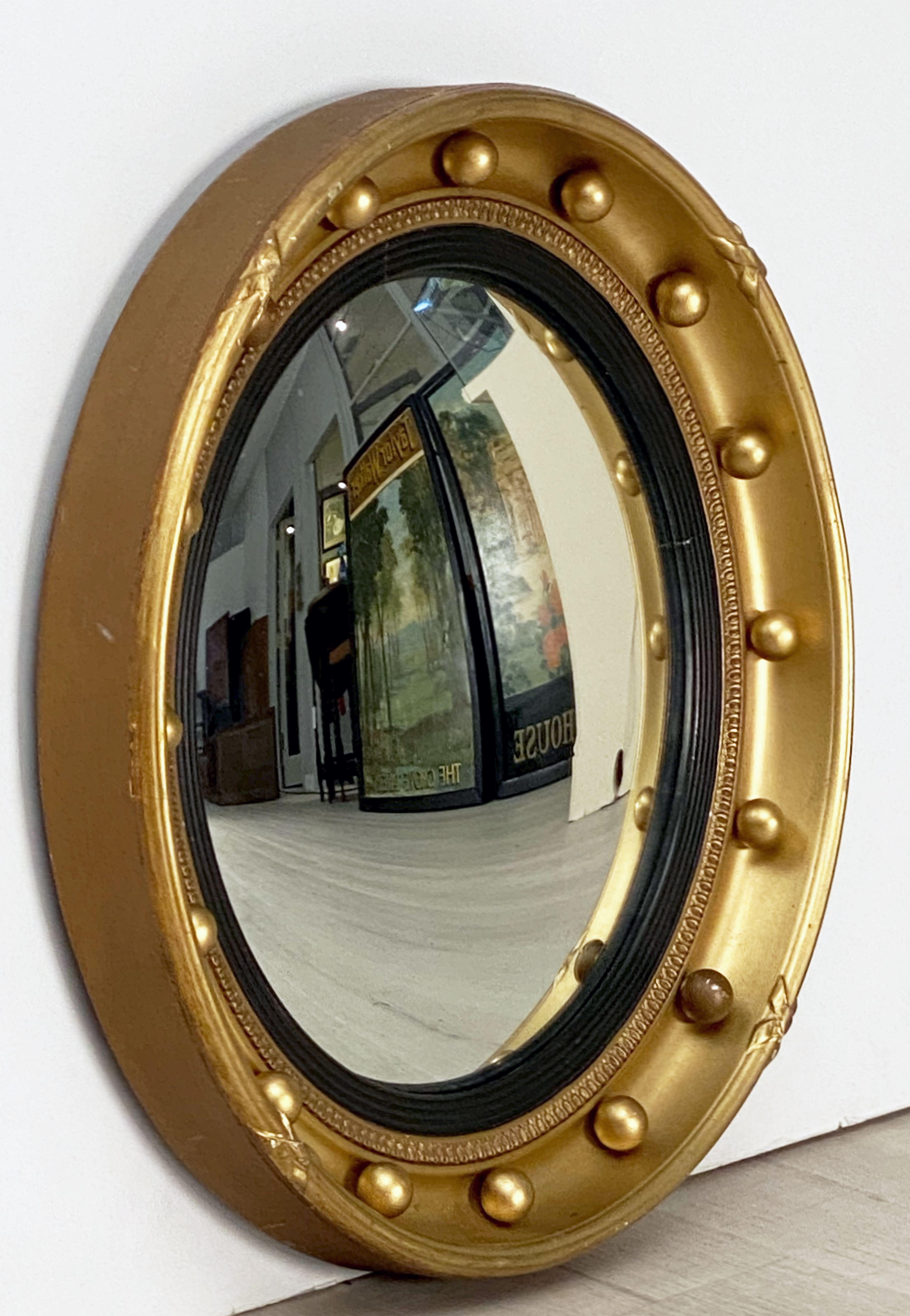 A fine English round or circular convex mirror featuring a Regency design of a moulded gilt frame and ebonized trim, with gilt balls around the circumference.

Dimensions: Diameter 16 1/4 inches x Depth 2 inches.