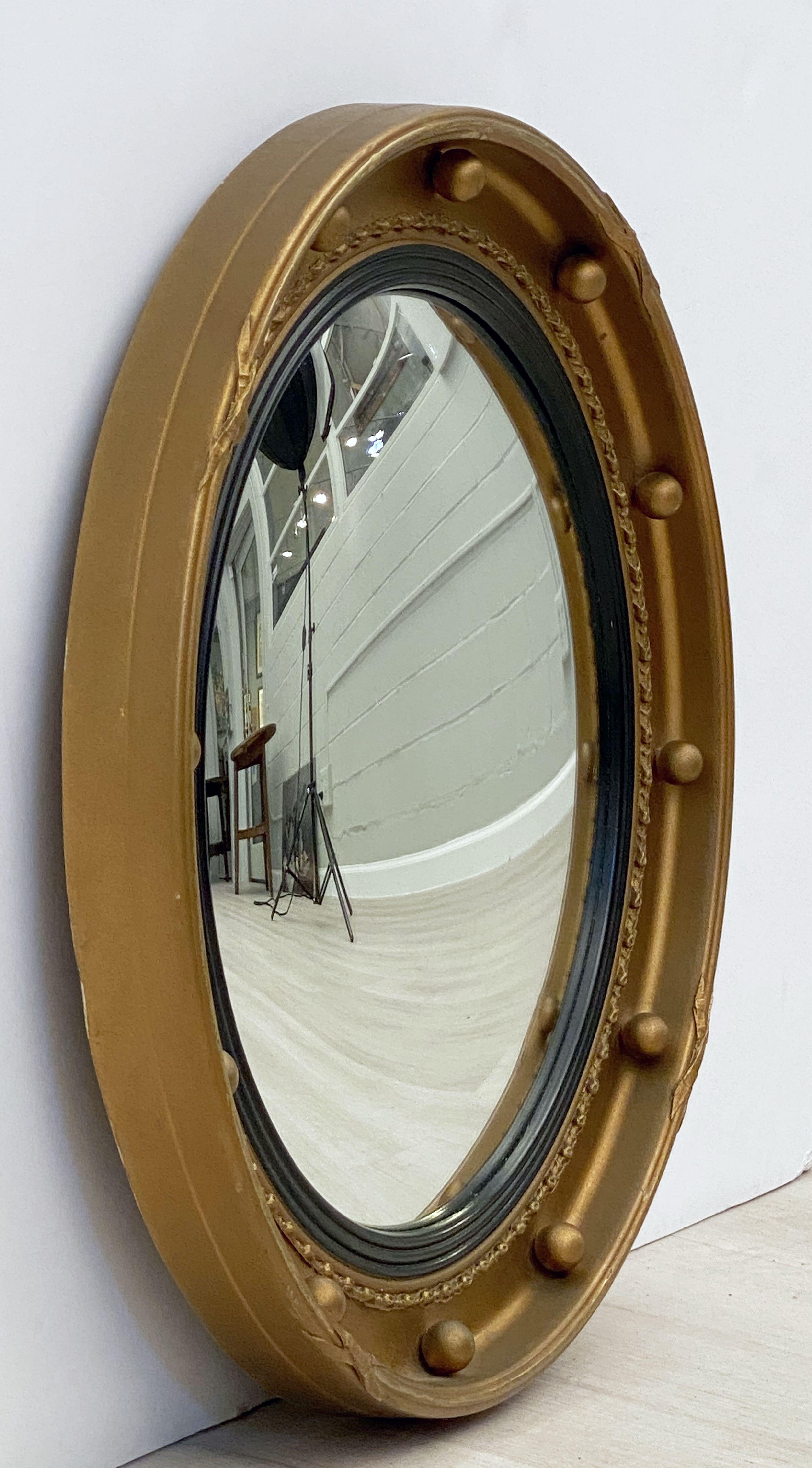 A fine English round or circular convex mirror featuring a Regency design of a moulded gilt frame and ebonized trim, with gilt balls around the circumference.

Dimensions: Diameter 18 1/4 inches x Depth 2 inches