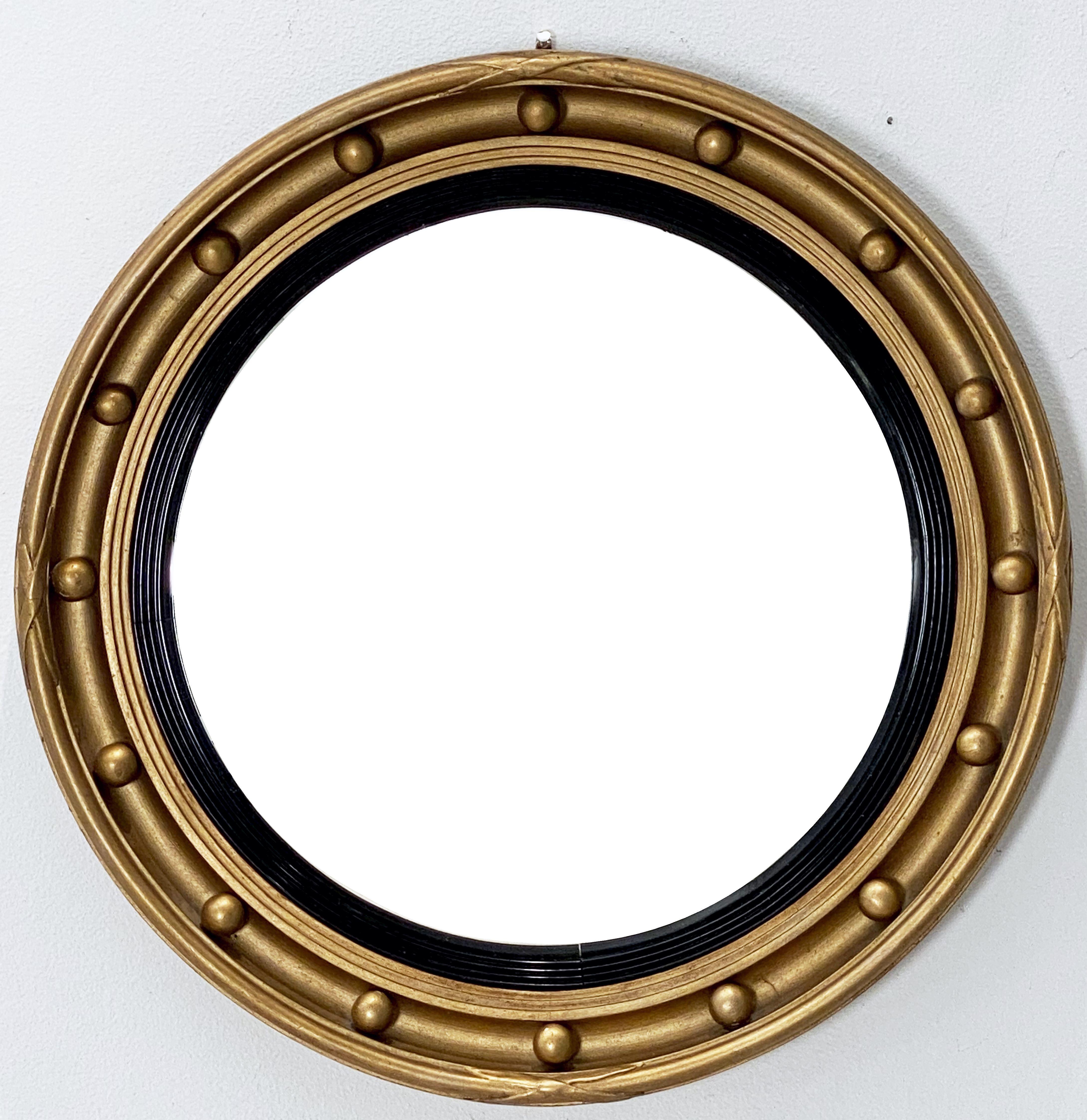 A fine English round or circular convex mirror featuring a Regency design of a moulded gilt frame and ebonized trim, with gilt balls around the circumference.

Dimensions: Diameter 18 3/8 inches x depth 2 1/4 inches.