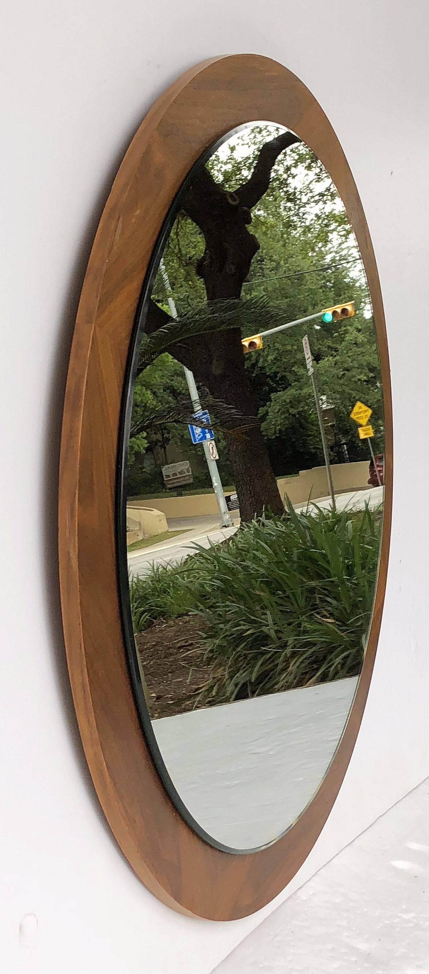 A fine English wall mirror featuring a round mirror mounted upon a circular teak wood backing.

Measures: Overall diameter is 27 1/2 inches

Round glass mirror diameter is 23 1/2 inches.