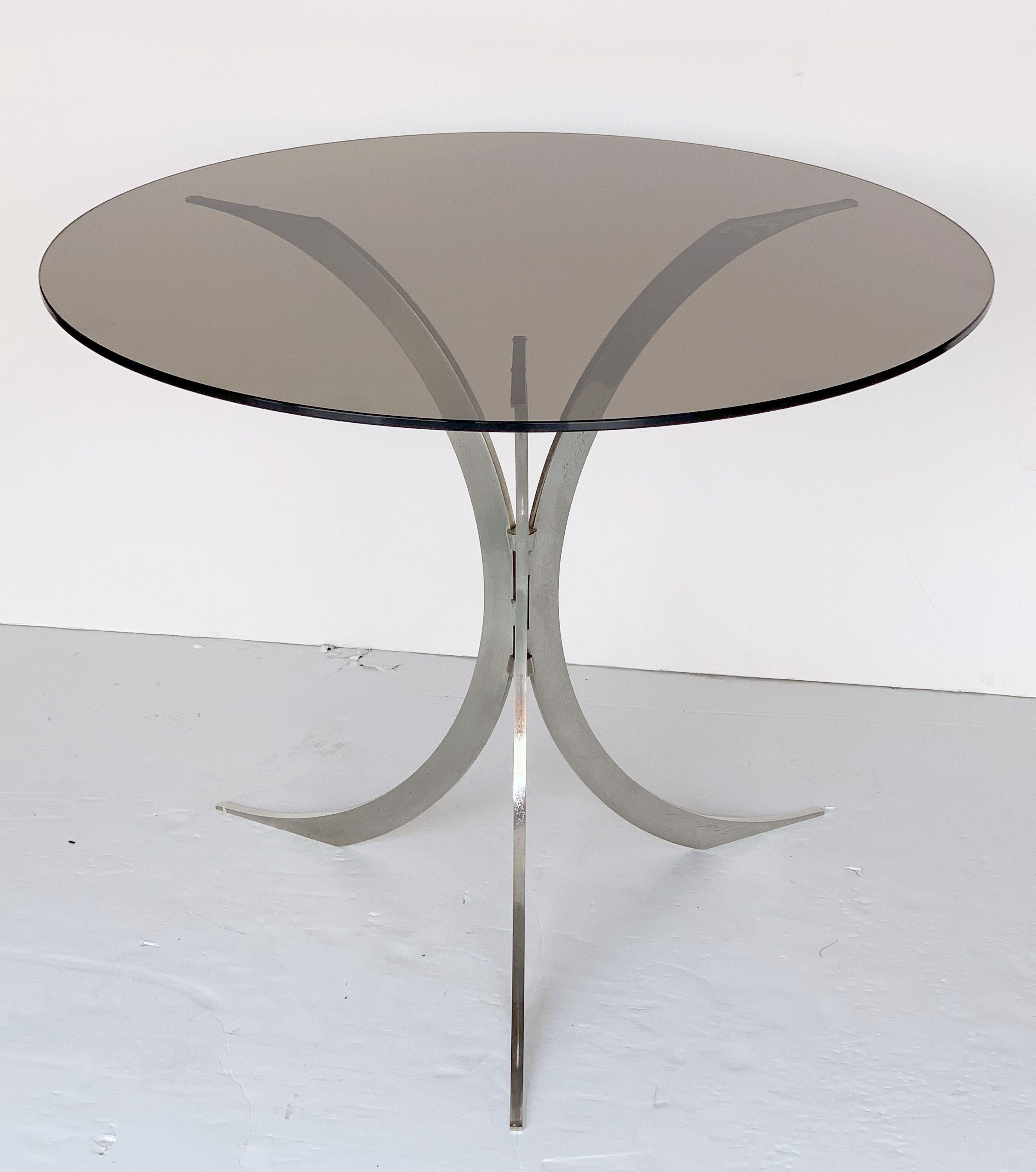 A stylish English round occasional table featuring a circular smoked glass top set upon a modern tripod base of chromed metal.

Measures: Height 28 1/4 inches x diameter 35 1/2 inches.