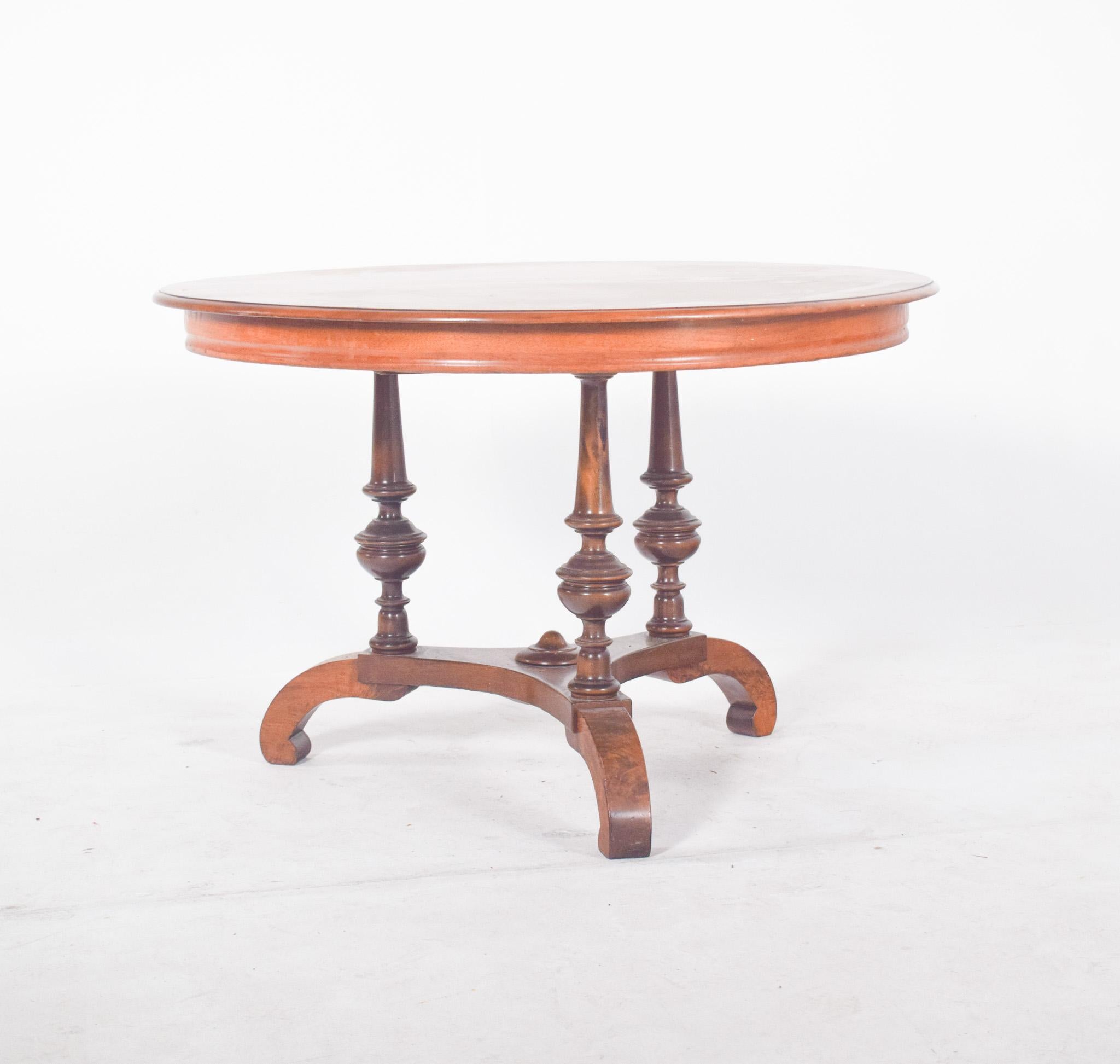 Round tea table in walnut. With a semi-circular backrest, it is made up of interlocking vertical rebars, creating an elegant and airy visual pattern. The seat follows the same pattern, providing comfort and flexibility. The slightly sloping legs are